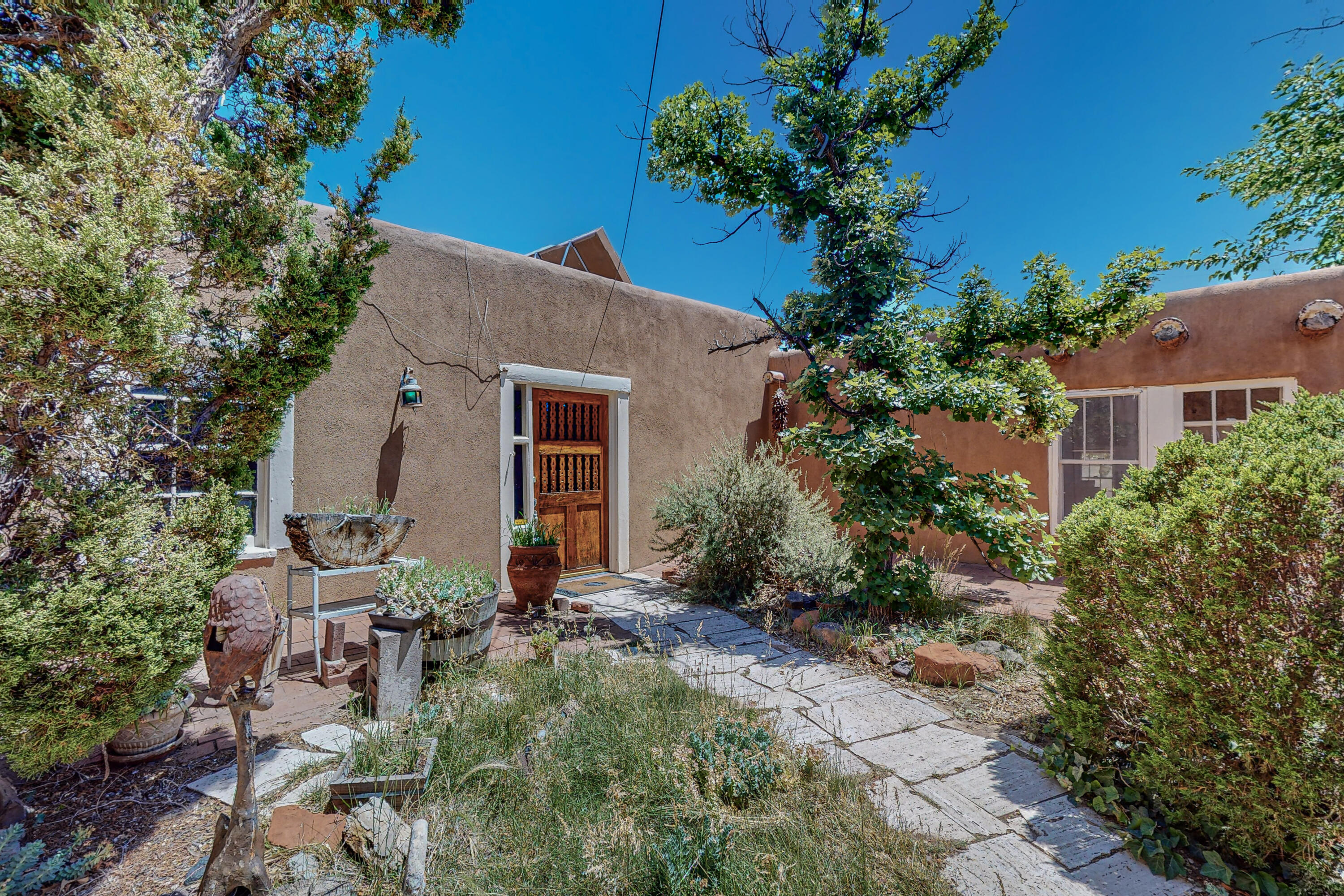 1 ACRE!!! Nestled in the heart of the North Valley of Albuquerque, this Adobe home and Casita stands as a testament to the rich history and Hispanic heritage that defines New Mexico. Set on a sprawling one-acre parcel of land in the North Valley, the property offers a rare glimpse into the area's unique past. The homes open living area, paired with a spacious dining room, makes it the perfect setting for gatherings and celebrations, capturing the essence of New Mexican hospitality. There's Kiva fireplaces throughout the home. The kitchen has been updated, boasting convenient pullout shelves while retaining its traditional charm.  The Casita has a separate entrance for added privacy. This property embraces the cozy and timeless appeal of SW style living.