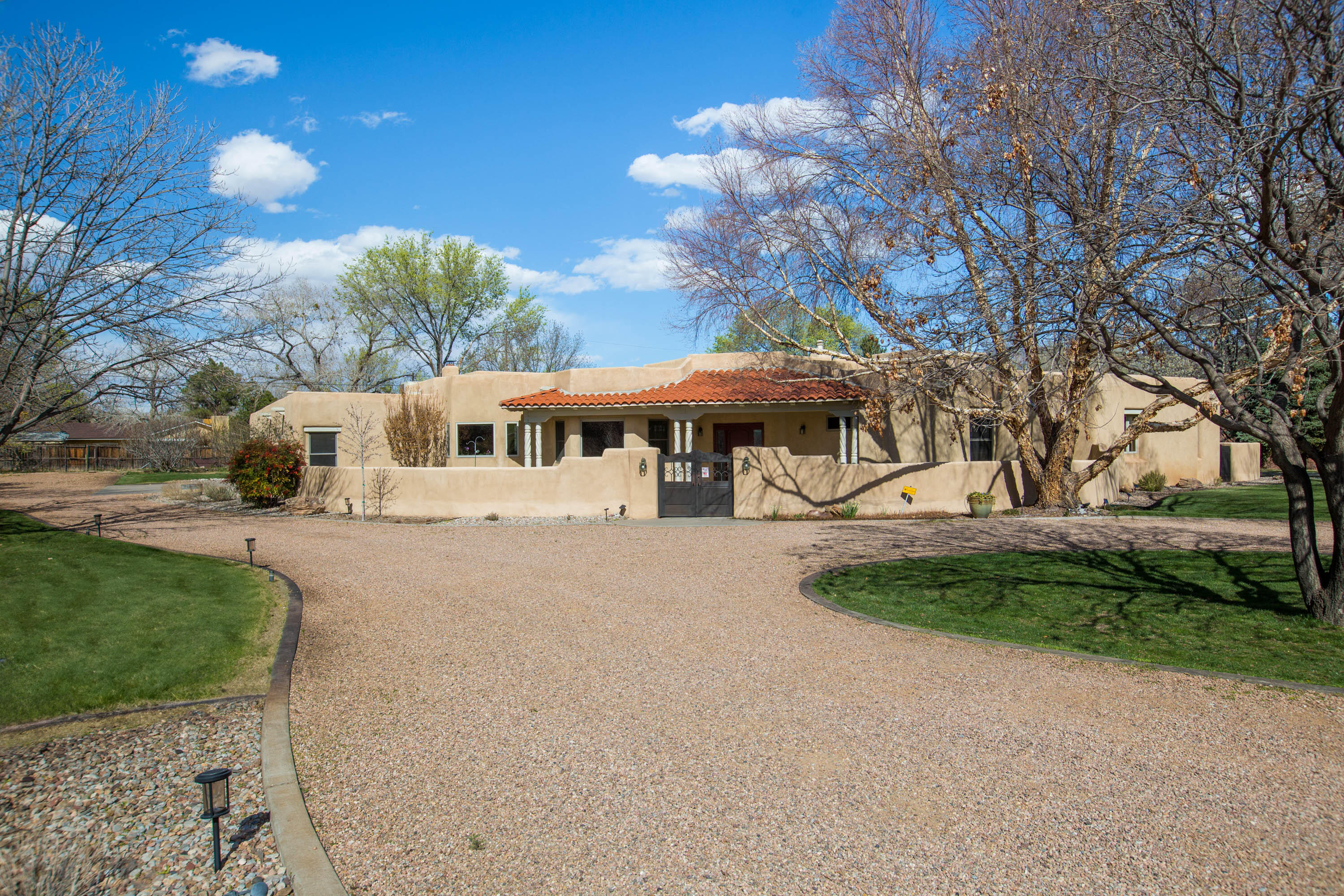 Exquisite Custom Home designed by Jim Beverly is situated on a beautiful, lush one acre lot. A tree lined, quiet cul-de-sac lane, in a highly desired North Valley neighborhood. Drive up to the circular drive and walk through the gated courtyard to this thoughtfully designed, and elegant home. An open and bright floor plan awaits, with views of your beautifully landscaped yard from nearly every window. The kitchen has double ovens, a large kitchen island and a walk in pantry. Two spacious living areas, a formal dining room, and a convenient buffet is ideal for entertaining. The family room has a stunning plaster fireplace designed and built by John Calvin. The primary bedroom is a combination of elegance and comfort, it has a sitting room with fireplace, two spacious closets, a jetted tub