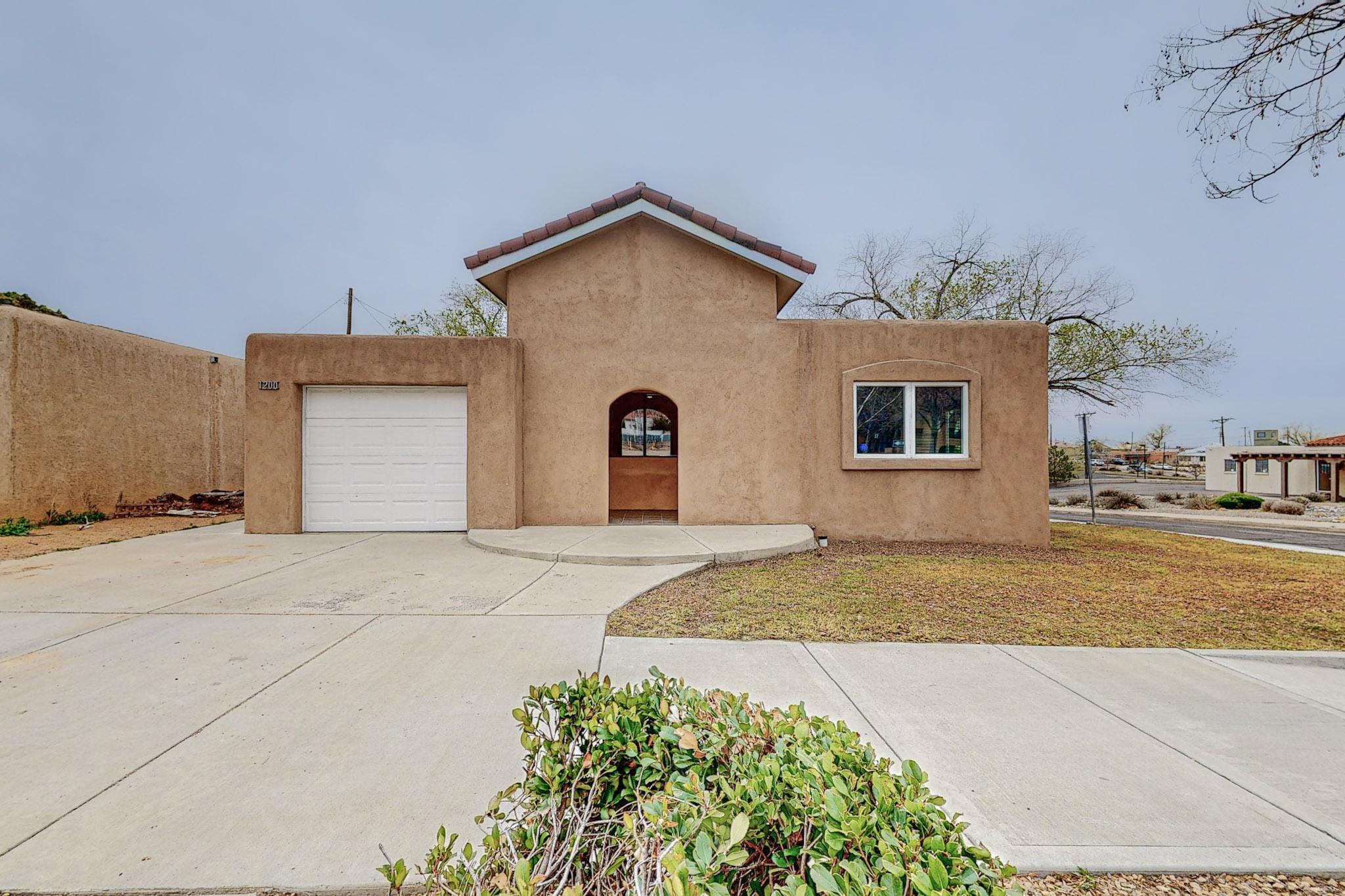 This home sits on a corner lot just two blocks from Presbyterian and only a few more to UNM, Nob Hill, CNM, and downtown. This home boasts 2 living areas, 2 bedrooms, 2 bathrooms, and original hardwood floors. Both bedrooms have ceiling fans as well as in one of the living spaces. From the light and airy kitchen, step through the French doors to your outdoor space. There is room to garden with a sprinkler system, a pergola to hang a sunshade from, and space for entertaining your friends and family. The garage comes equipped with a full-size washer and dryer and space for a workshop or storage. Come take a look at this wonderful home in a great location. New Roof (2022), Dryer (2024), Hot Water Heater (2024), New Paint (2024)