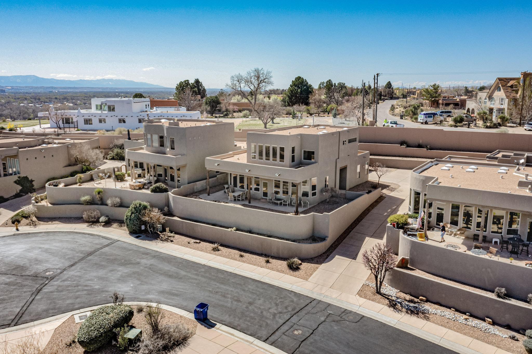 Sit back, relax and take in stunning panoramic views of the Rio Grande Valley stretching all the way to the majestic Sandia Mountains from this exquisitely crafted home. Built by renowned local builder Scott Patrick, this single-story masterpiece is nestled in one of Albuquerque's most exclusive gated communities. Soaring ceilings and expansive windows flood the open-concept floor plan with an abundance of natural light, creating a bright, inviting atmosphere to unwind at the end of the day. Gourmet chefs will appreciate the beautiful kitchen featuring granite countertops, sleek stainless steel appliances including a professional gas range. Relax in absolute luxury in the lavish primary suite, complete with a large jetted tub  with views.