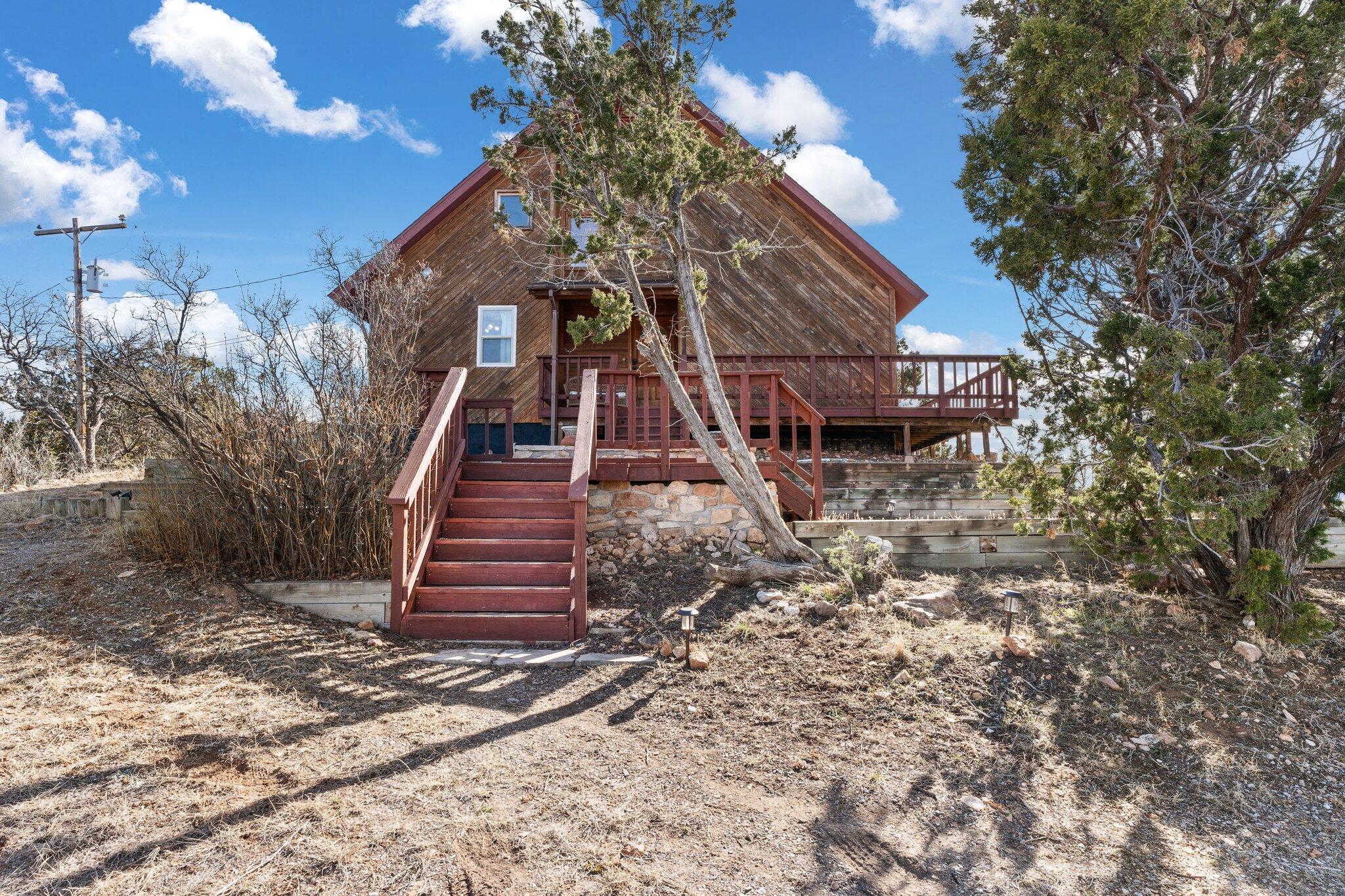 Escape to this enchanting mountain sanctuary in Sandia Knolls! Situated on .85 acres, this exquisite home features three bedrooms, two bathrooms, tongue & groove ceilings, a wood-burning stove, updated vinyl flooring, and windows. Delight in the upgraded kitchen with newer cabinets and stainless steel appliances. Bask in the tranquil vista of the Sandia mountains from the sunroom or the wraparound deck. Seize this chance to possess your own slice of paradise!