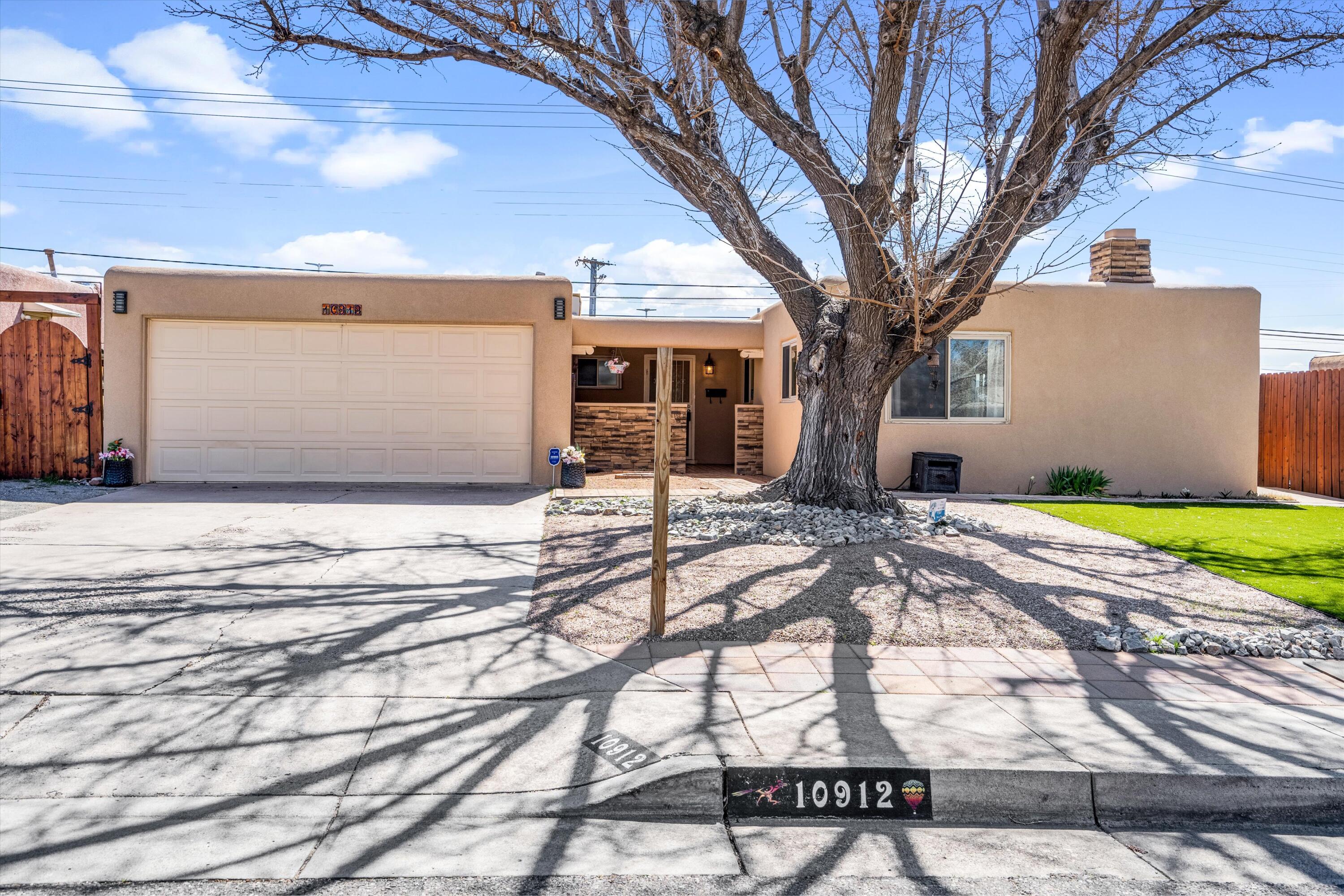 MODERN CLASSIC NE Heights 4-bedroom home! This rare find spans over 1800SF with 2 living areas, including a cozy family room with kiva fireplace, and a spacious living room that seamlessly connects to dining. The home welcomes you in with private courtyard and a cozy front porch seating area. Pristine landscaping with mature shade tree elevates its curb appeal. Inside, the beauty of gorgeous wood flooring extends throughout, A U-shaped kitchen is adorned with snazzy tile backsplash, and a mini-beverage coffee bar, perfect for morning delights or evening beverages. Large fenced yard, complete with deck and pergola, an ideal setting for outdoor dining and barbecues. Surrounded by parks and the finest Albuquerque eateries and entertainment options, this one won't last long! Call today!