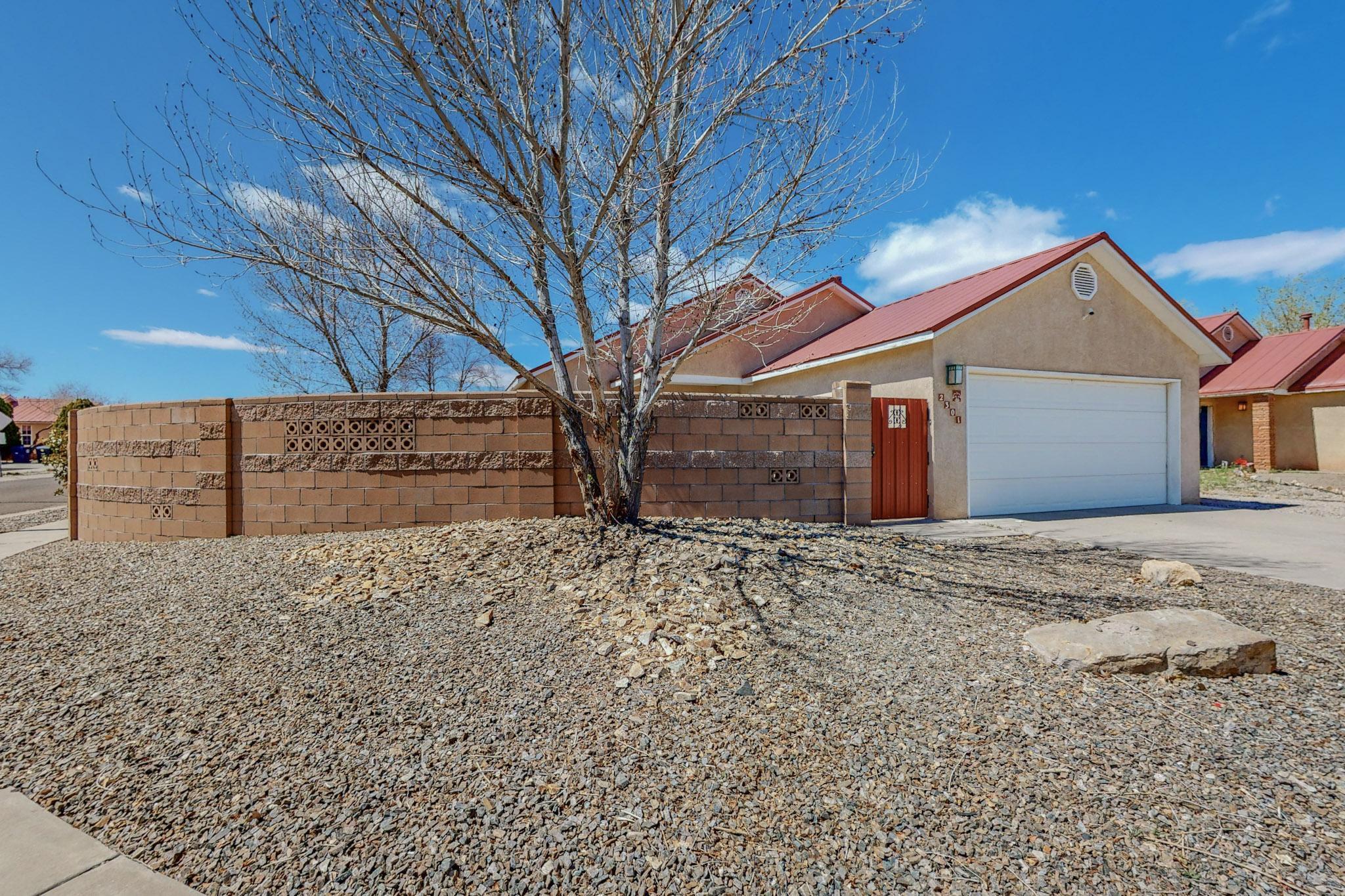 Conveniently located, 2301 Tompiro Dr NW offers modern sophistication and comfort. This meticulously maintained property features three bedrooms, two bathrooms, and open floor plan that seamlessly integrates living, dining, and kitchen areas. High ceilings and a stylish kitchen with stainless steel appliances create a welcoming atmosphere. The master suite serves as a private retreat, while two additional bedrooms offer flexibility. Outside, the landscaped yard features a charming pergola and a gas hook-up for outdoor gatherings. A beautifully finished wall surrounds the backyard, providing privacy and a sense of seclusion. The property sits on a corner lot with convenient vehicle side access into the yard. The location offers nearby access to trails leading to the Rio Grande Bosque