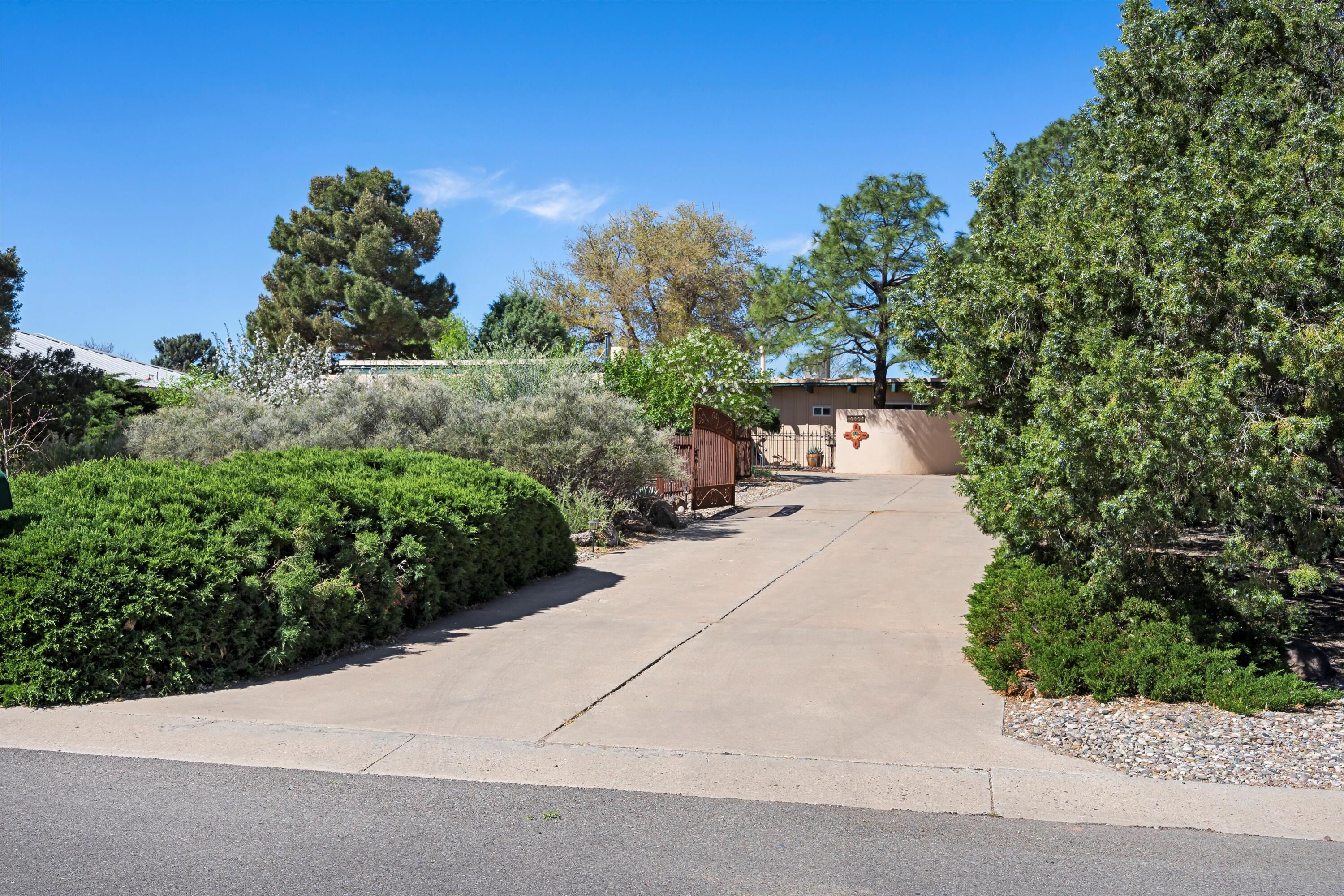 Welcome home to this meticulously maintained home located on the first hole of the Paradise Hills Golf Course. This 3-bedroom, 2-bathroom home features new premium vinyl plank flooring and a new ultra high efficiency Lennox refrigerated air conditioner and heating system which is controlled with a smart thermostat. It also has a TPO roof with a fresh tune up that will providedurability and longevity for years to come. The 5 skylights, open floor plan, and abundance of windows provide a light and bright environment perfect for entertaining. Beautiful iron drivewaygates and front fencing provide additional privacy. Sit in the secluded front area to enjoy your coffee, bird watching, the morning sunrise, or our amazing balloon fiesta. With a detached 2 car garage, ample storage