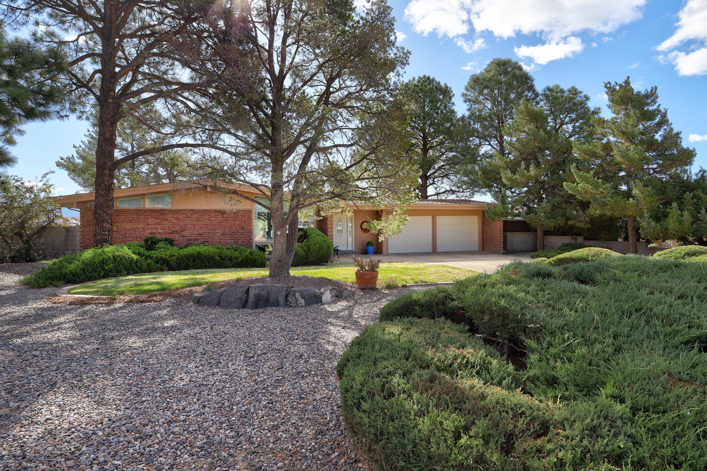 This home is a must see! The two possible living areas provide ample space for relaxation, benefiting from natural light and refrigerated air conditioning for year-round comfort. The kitchen is equipped with modern appliances and generous counter space, catering to both everyday cooking and hosting gatherings. French doors lead to the expansive backyard, perfect for outdoor activities and enjoying mountain views. The bathrooms feature radiant heating for added comfort and have been recently updated with contemporary finishes. The property also is complete with sprinkler systems for easy maintenance and attractive landscaping that adds to the curb appeal. Experience the charm of 9818 Greene Ave NW and schedule a tour today to explore all that this home has to offer.