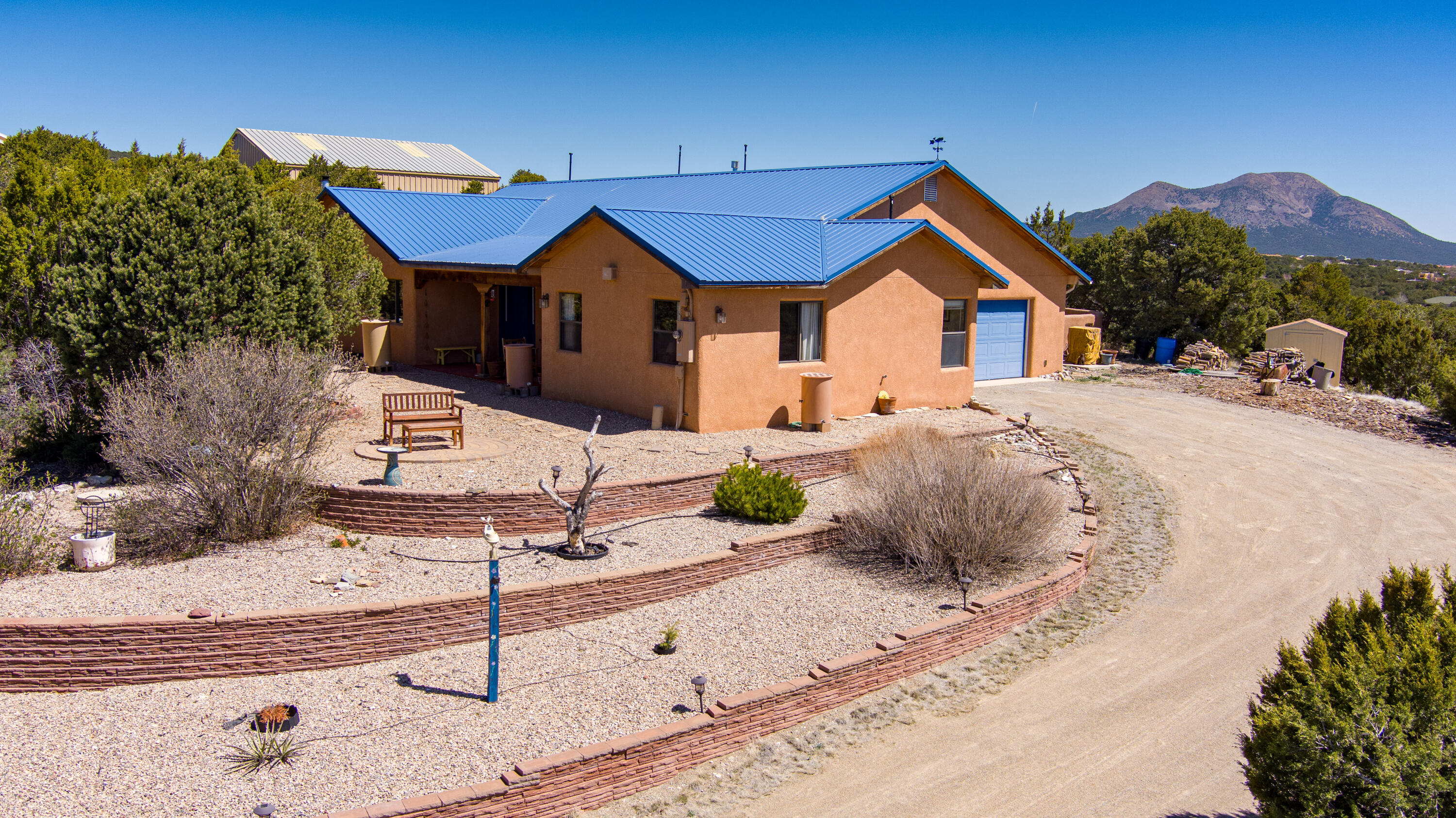 Open House Sat, 4/20, 11-1pm, Sun 4/21, 2-4pm.  First time offered! This custom dream retreat nestled atop a wooded hill, offers serenity and stunning views of the majestic Sandia Mountains. This warm and inviting single-level home boasts 3 bedrooms plus an office, perfect for work-from-home days. With 2 spacious living areas and a thoughtfully designed open floor plan, this home is ideal for relaxation and entertaining. Custom wood cabinetry crafted by a local artisan adds character and charm throughout. Step outside to your private courtyard oasis, complete with lush gardens and a covered porch, perfect for enjoying the tranquil surroundings. Hardwood floors enhance the cozy atmosphere. Oversized 2-car garage & shed. Paved roads, community water, underground utilities, (con't)