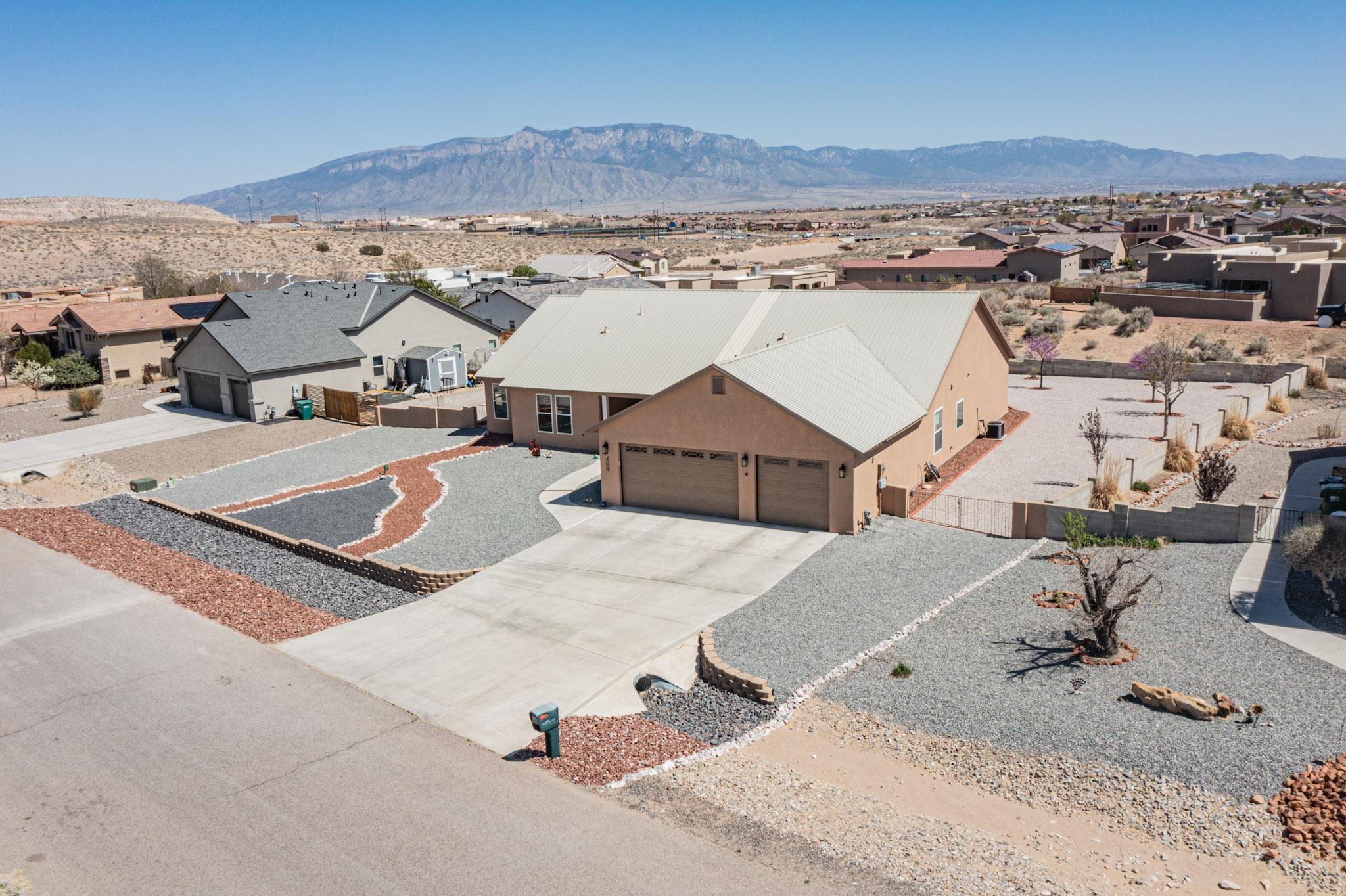 This beautifully built single-level home has five huge bedrooms and boasts incredible views of the Sandias. It features an open floor plan with stunning oak wood floors, all-new premium window coverings, and brand-new stucco and exterior paint. Enjoy your breakfast in the bright and spacious kitchen with stainless appliances throughout and a walk-in pantry, relax after work in the living room in front of the gas fireplace, and end your day by relaxing in the sunroom and checking out your beautiful mountain views. Outside, you'll find all-new landscaping and hot tub with a gazebo surround! The finished garage has a workbench, oversized garage doors, and pull-down attic space. Side yard access has plenty of space to park your RV or boat. Don't miss out on making this incredible home yours!