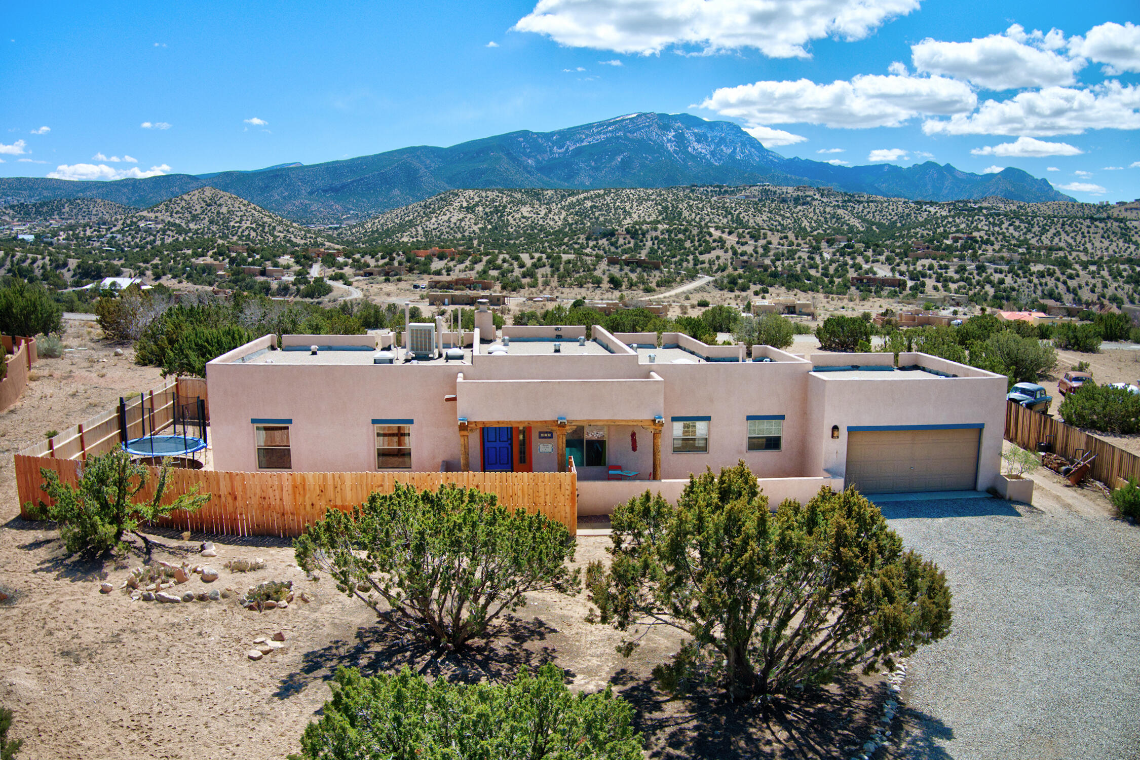 Views Views Views!! Affordable Placitas custom Pueblo style home features 3 Bedrooms and 2 FullBaths. Single story. Well maintained. Open main living area with awesome Sandia views from the LivingRoom, Primary Bedroom & Primary Bath and Eating Area. The Dining Room could flex as an Office orLibrary space. The Pueblo style features exposed beamed ceilings, kiva fireplace, Saltillo tile and woodlooklaminate floors. There is ample cabinet and counter space in the Kitchen with a breakfast bar (allappliances stay). Outdoor living expands to the covered front and back patios, plus extra fencing forprivacy. 1 acre lot with flat, useable land. Separate Laundry Room leads to oversized 2 car garage.Water heater installed in 2023. Reasonable covenants. Welcome Home!