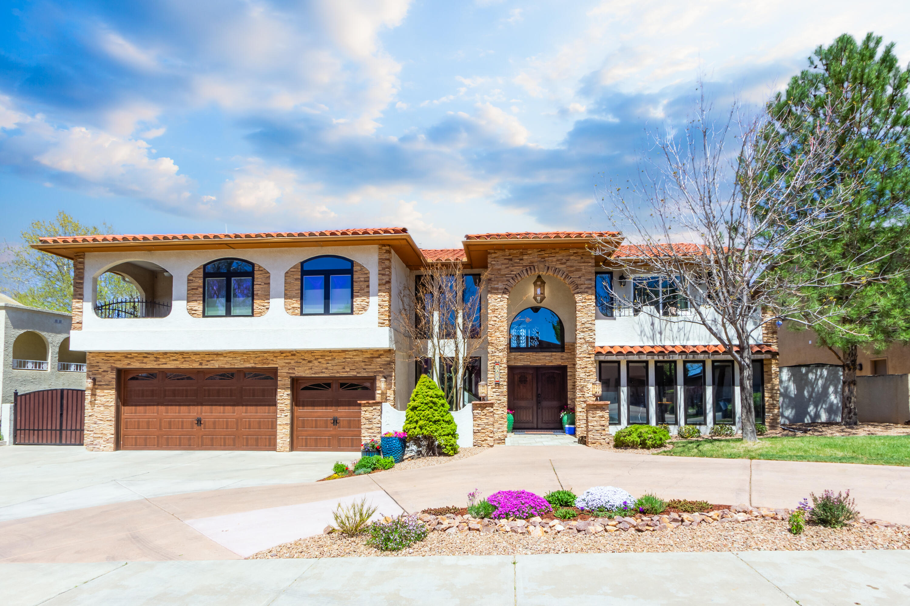 Step into a home of enduring elegance! Embrace a fresh outlook, a fresh deal, and a fresh vibe in this luxurious haven nestled within Albuquerque's prestigious gated community. Meticulously maintained by one family for over two decades, this residence boasts immaculate upkeep, ensuring no deferred maintenance issues. Revel in the allure of an updated gourmet kitchen adorned with top-tier appliances, seamlessly blending with a chic dining area and flowing into a grand great room with soaring ceilings reaching nearly 20 feet above polished wood floors. Designed for seamless entertainment, three access points to the expansive manicured backyard and covered patio invite leisurely gatherings. Discover four generously sized bedrooms, each offering comfort and style, while an optional fifth