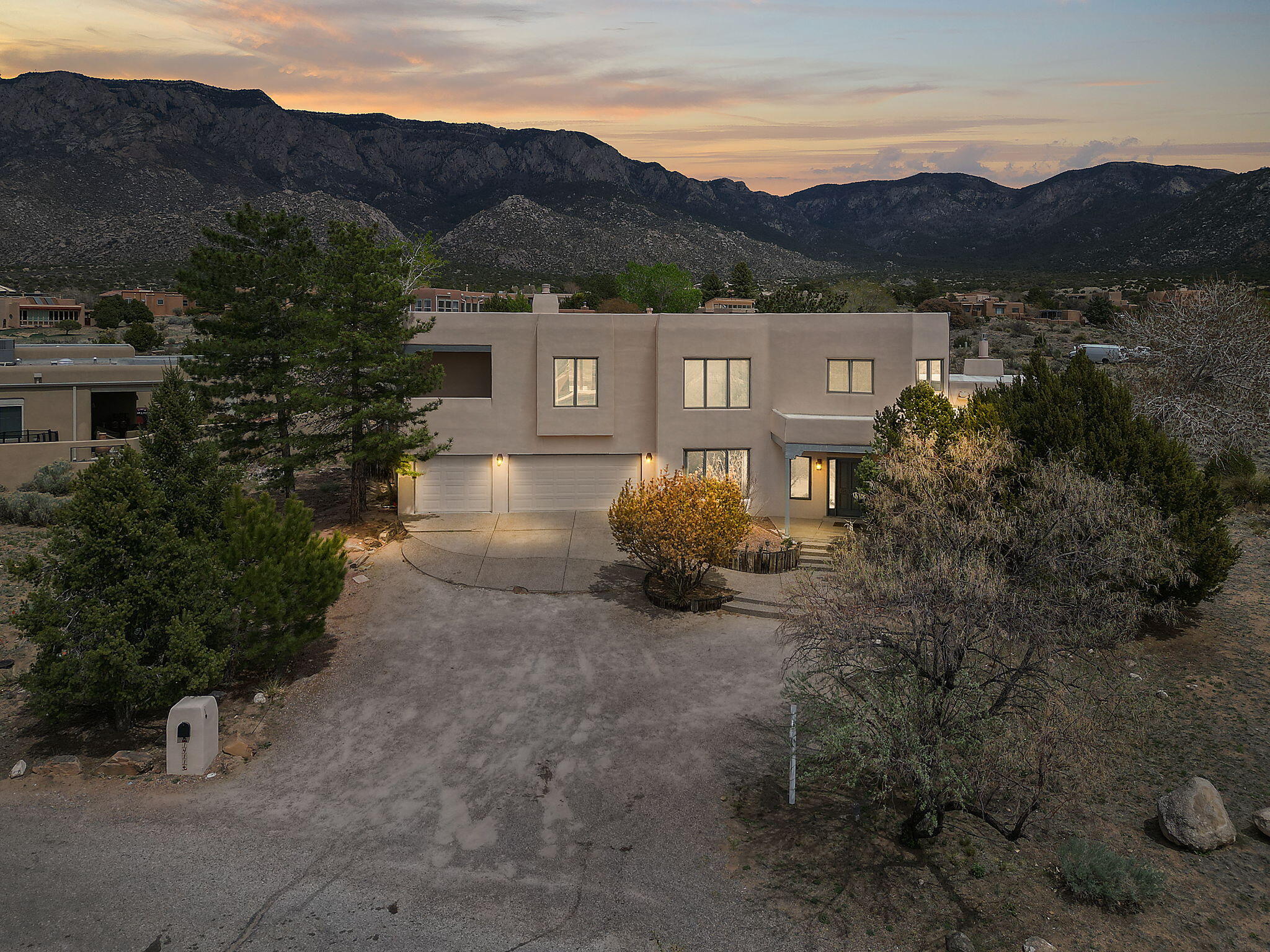 Welcome to this charming haven on an exceptional elevated cul de sac lot in much sought after Sandia Heights! This Custom David Hunt home offers an open layout, abundant natural light, dramatic raised ceilings, and stunning Sandia Mountain and city VIEWS! Perfect floorplan for a multi-generational family as home features an in-law quarters separate from the rest of the home. The kitchen boasts modern appliances, ample storage and gorgeous new light fixtures. Retreat to the serene primary suite with balcony and fireplace or enjoy the fully landscaped backyard with captivating views and hot tub!  Recent updates include: new upper TPO roof (2024), freshly painted interior, new carpet in primary suite, new sprinkler system, new hot tub cover, new fireplace & new AC head unit for in-law suite