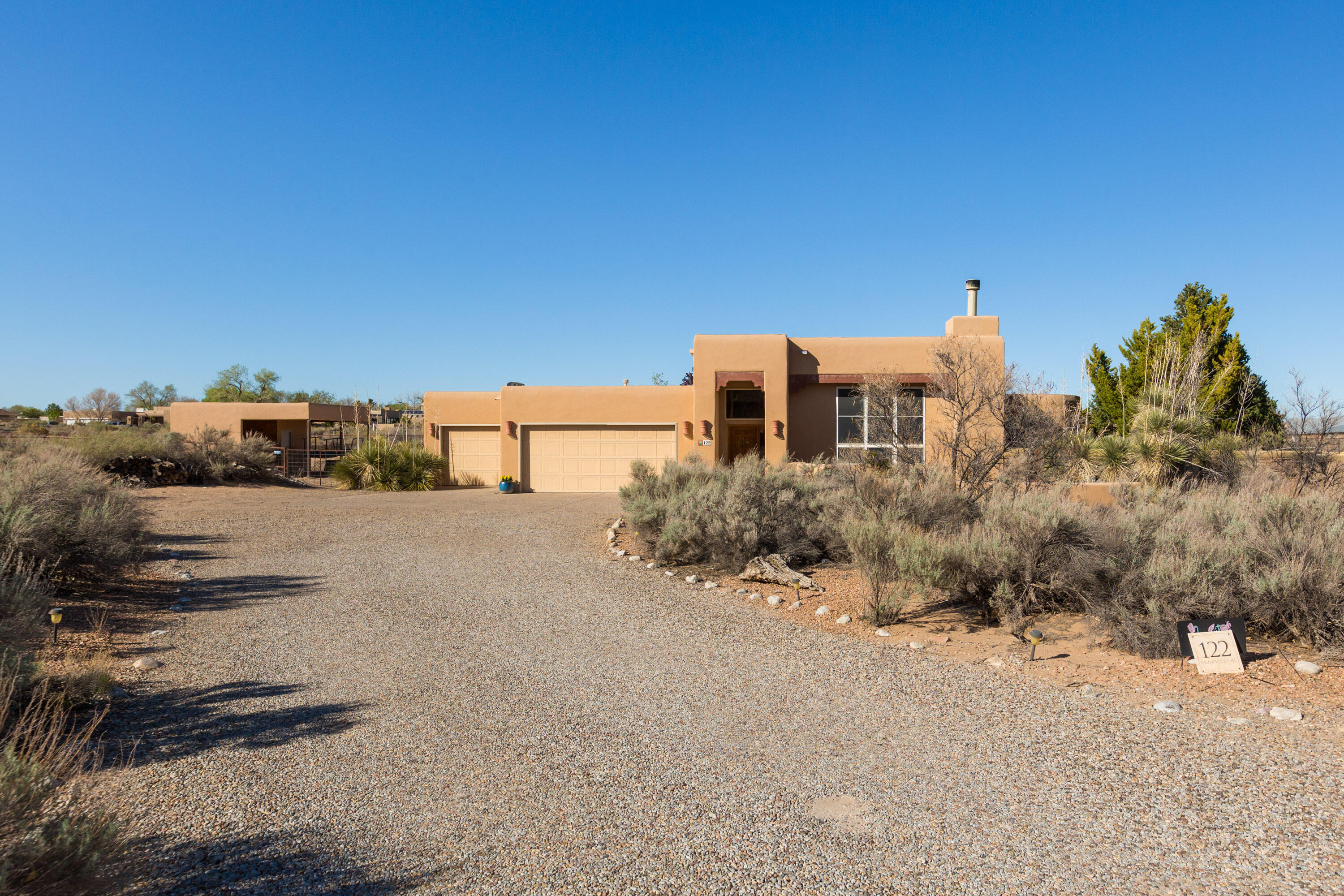 Stunning southwestern contemporary sporting tile and hardwood floors, walls of windows, adobe accents, beams, corbels and lintels. Views! Gourmet kitchen with Wolf stainless double ovens and gas cooktop, Asko dishwasher and and LG refrigerator+ pull out shelves. Breakfast area with curved wall of windows and  two doors to two separate patios. High ceiling living room with hardwood floors, gas stacked stone fireplace and lots of light. The Owners' Suite has a wall of windows showcasing the pool and spa with a lovely view of the Sandia Mountains. A gas fireplace warms the room while a door leads to the patio, pool and spa as a Tai Chi area nestles in a corner. A pipe horse fence wraps around back with hay storage/tack room and room for a couple of horses or other animals.  Sooo Corrales!