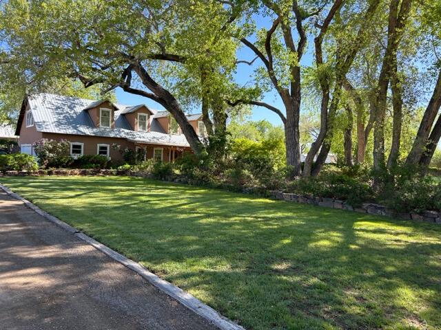 Nestled in 100 yr old cottonwood trees, this impressive 2 story Northern NM style home has all the charm Corrales has to offer. Located on 1 of the most desirable streets in the Village, offered for sale for the 1st time.  Gated 1 acre, landscaped for beauty & tranquility. Home boasts radiant floor heat downstairs/hot water baseboard heat upstairs. Updated kitchen w/all stainless appliances, soapstone countertops, new cabinetry, walk-in pantry, The large picture window Views of 1/2 acre grass pasture ideal for animals lg & sm. Living room views the bosque & mountains & your rose garden. Masterbath highlighted by antique cabinetry w/lg walk in closet. Upstairs has antique pine flooring w/lg bedroom/full bath, walk in closet & huge living room w/views of Sandias.  3 car finished garage