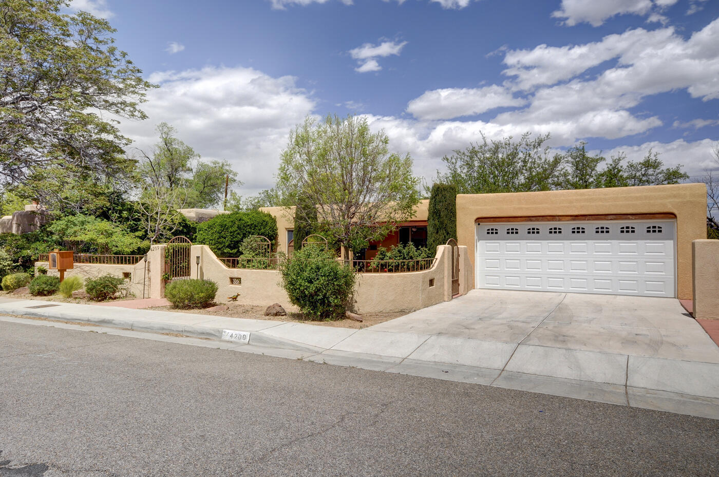 The courtyard entry,  with 2 water features & mature landscaping sets a tranquil tone for this charming 2 BR, 1 bath bungalow.  The eat-in kitchen is flanked by living room/dining room on one side with  expansive service room w/deep sink, storage,  & washer/dryer on the other. Remodeled full bath serves two spacious bedrooms easily. Hardwood & ceramic floors add a touch of elegance ensuring easy maintenance.  Morning coffee on the front porch or relaxing on the expansive covered back patio, there's no shortage of restful spots to unwind.  Refrigerated air ensures comfort.  A 2 car garage & ample storage  provide plenty of room for all your belongings. The blend of comfort, style & functionality equals a perfect retreat.  The  convenient established neighborhood make this a must see!