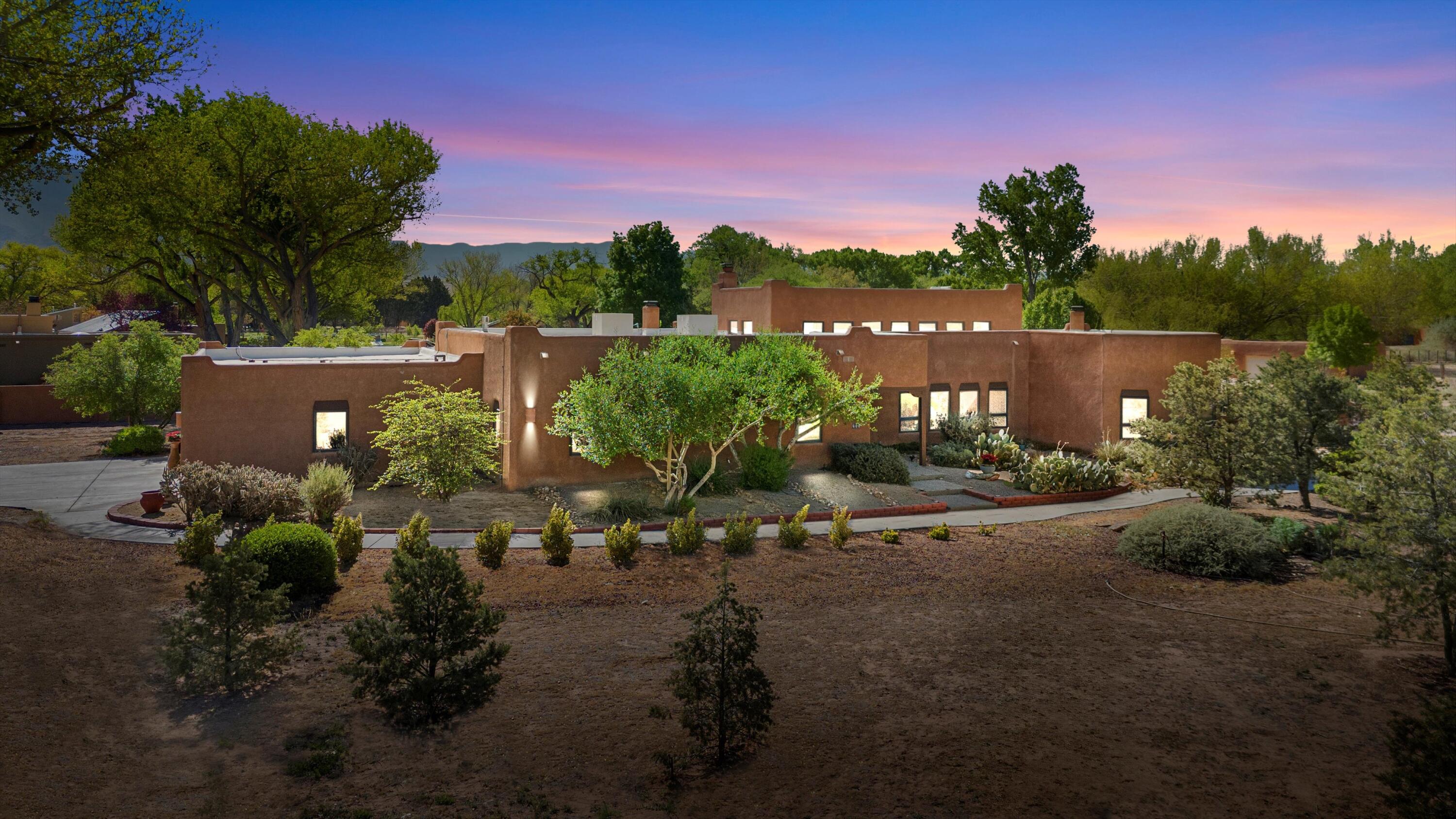 SOUTHWEST ENCHANTMENT at 400 Camion De Lucia with stunning mountain views and great location for spectacular viewing of the balloon fiesta! Situated on a full-acre, this custom Pueblo-style home is an architectural masterpiece. Cathedral-height viga and wood beam ceilings, 3 indoor Kiva fireplaces, 3 genuine interior adobe walls and luxurious Saltillo tile ensures New Mexico charm at every turn. Large windows bathe the home in sunshine and raised ceilings provide perfect lighting to transform the hallway into an art gallery. 3 beds, 2 baths, and 3 living areas plus gourmet kitchen with built-ins and cooking island.  Expansive master, with 2 walk-ins! 2 outside courtyards, with 4th kiva fireplace to enjoy autumn or winter evenings. All this in lovely Corrales! Call today!