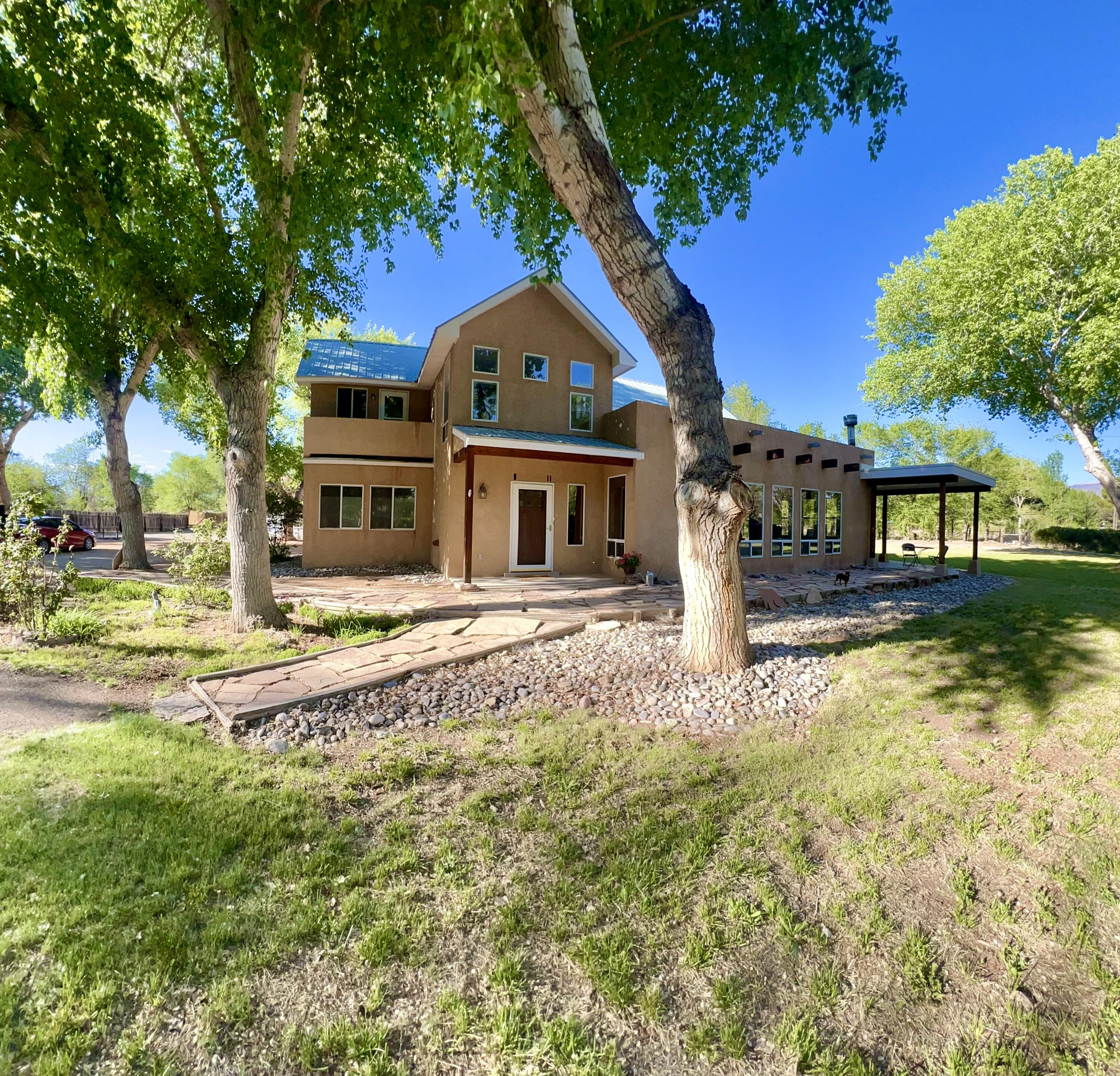Classic Elegance Northern New Mexican Home in a gorgeous Corrales location, amidst the Cottonwood tree-lined ''green belt''. Welcome in! Spacious lofty beamed ceilings begin at the front foyer. The main floor hosts a luxuriously sizable great room, open kitchen to include granite countertops, island cafe, dining area,  a large bedroom / office, full bathroom near by laundry service. Top floor, the two bedrooms boast  private balconies with views & 2 full baths. Throughout the home: well appointed passive solar windows provide natural opulent lighting. Refrigerated air, dual heating systems CFA & radiant floor heat will optimize your comfort all four seasons. Outside East facing, truly phenomenal covered patio with panoramic views of the Sandia Mountains. ONE ACREpre-1907 Irrigation WR*