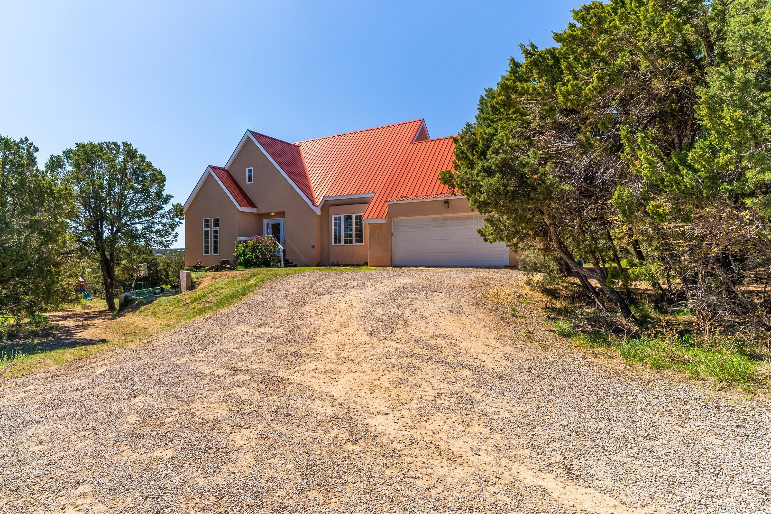 OPEN SAT 4-6, SUN 1-4 PM. Welcome to 63 Pine Ridge, located in the heart of Sandia Park with quick access to both N-14 and ABQ, and Edgewood, plus award winning San Antonito schools/district with plenty of room for your family to stretch out and run around. This 5 bedroom (plus office area), 3 bath, 4005 square ft colonial style home sits on 2 fully fenced acres, has a heated/finished walk-out basement/rec room, with outdoor patio and parking pad, and is nestled in the trees, providing lots of privacy with all the convenience of paved roads and local amenities. Freshly painted, updated appliances and bathrooms, are among the many updates done to the property since 2019. You can't beat the location or the layout/functionality of this home for your family! Come take a look today!