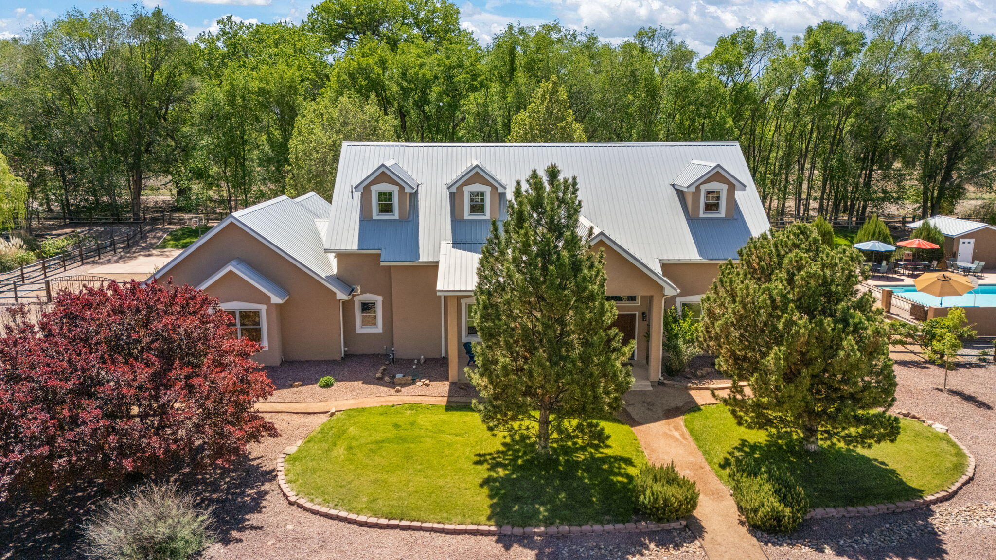 Come home to this pristine estate in the heart of the exclusive Bosque del Rio neighborhood! With all the bells and whistles, this is a truly unique opportunity.  With just over an acre of land, and PRIVATE Bosque Access, this is an absolute oasis.  Step into soaring ceilings, gorgeous wood laminate floors, and space for everyone.  Main level showcases an oversized living area with Kiva Fireplace, guest quarters, Chef's Kitchen complete with gas range and New Quartz counters, and an oversized Primary Suite with Kiva Fireplace, spa-like ensuite, and access to the backyard.  Upstairs are 2 additional bedrooms with a possible 3rd (for a total of 5 possible bedrooms) plus loft area.  And don't miss the great outdoors!! Sparkling Saltwater Pool and Hot Tub with HUGE surrounding deck, Easy to