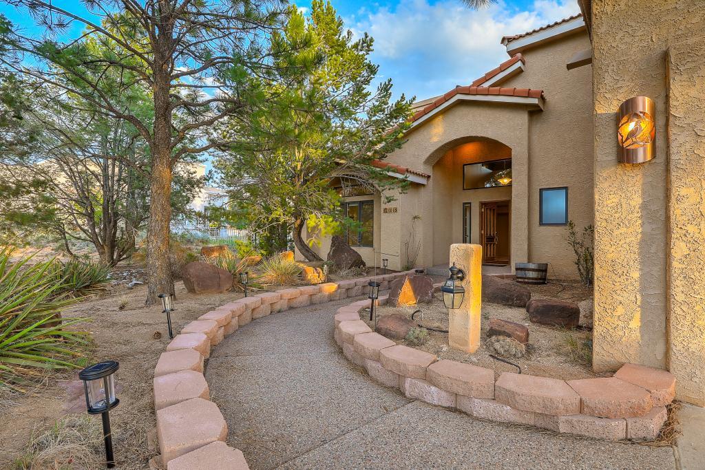 Enjoy the tasteful elegance of a custom-built Ogelsby home in the coveted Sandia Heights! This home showcases a functional layout with an office, 2 primary suites (upstairs and downstairs), great room, dining room/flex room, and kitchen with a dining area. The primary suite is beautifully upgraded with a picture window framing the Sandia Mountains and a large walk-out balcony with city views. The spa-like primary bathroom is fully renovated with a soaking tub, glass enclosed shower, a walk-in closet, and RADIANT HEAT flooring. Save with the high efficiency refrigerated air units and gas furnaces. Take in the comforts of a whole house humidifier, water softener and kitchen water filtration system. Delight in high ranking schools. An incredible home and opportunity await.