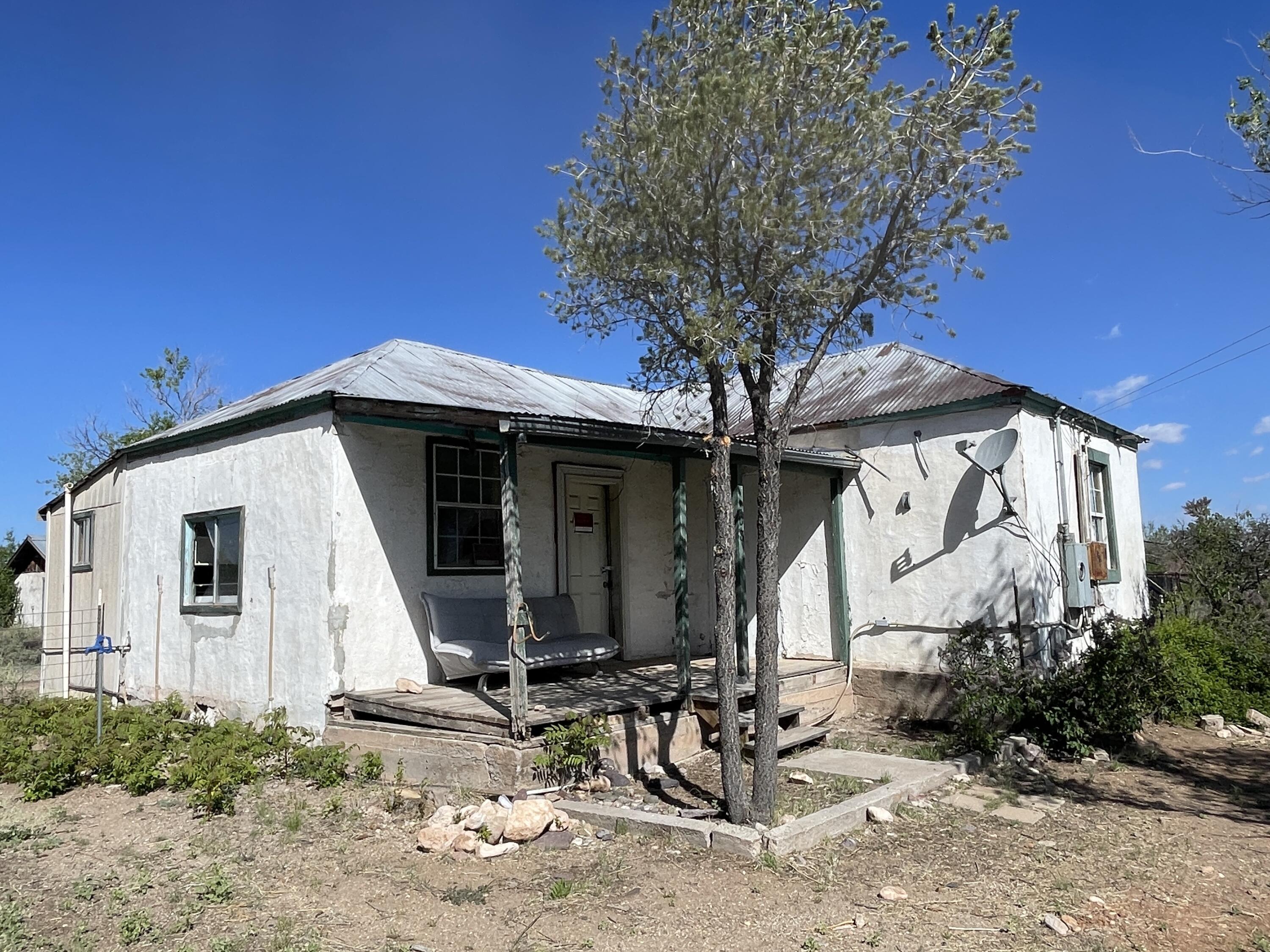 A diamond in the ruff in the historic Village of Magdalena just off of HWY 60  This 900 SF. Adobe Fixer Upper would make the perfect, rental, Airbnb or your forever home in the high desert. Two bedroom, one full size bathroom. Open floorplan in living room and kitchen. Kitchen area has a lot of potential for a spacious workable cooking area. Out building would be a perfect spot for an art studio or workshop.  Fantastic New Mexico sunsets and dark starry skies. Enjoy the majestic mountainous views of the Magdalena Mountains!  Additional lots to the west can be purchased with this property, Come and make this gem yours today! Won't last long! Call for a tour today!