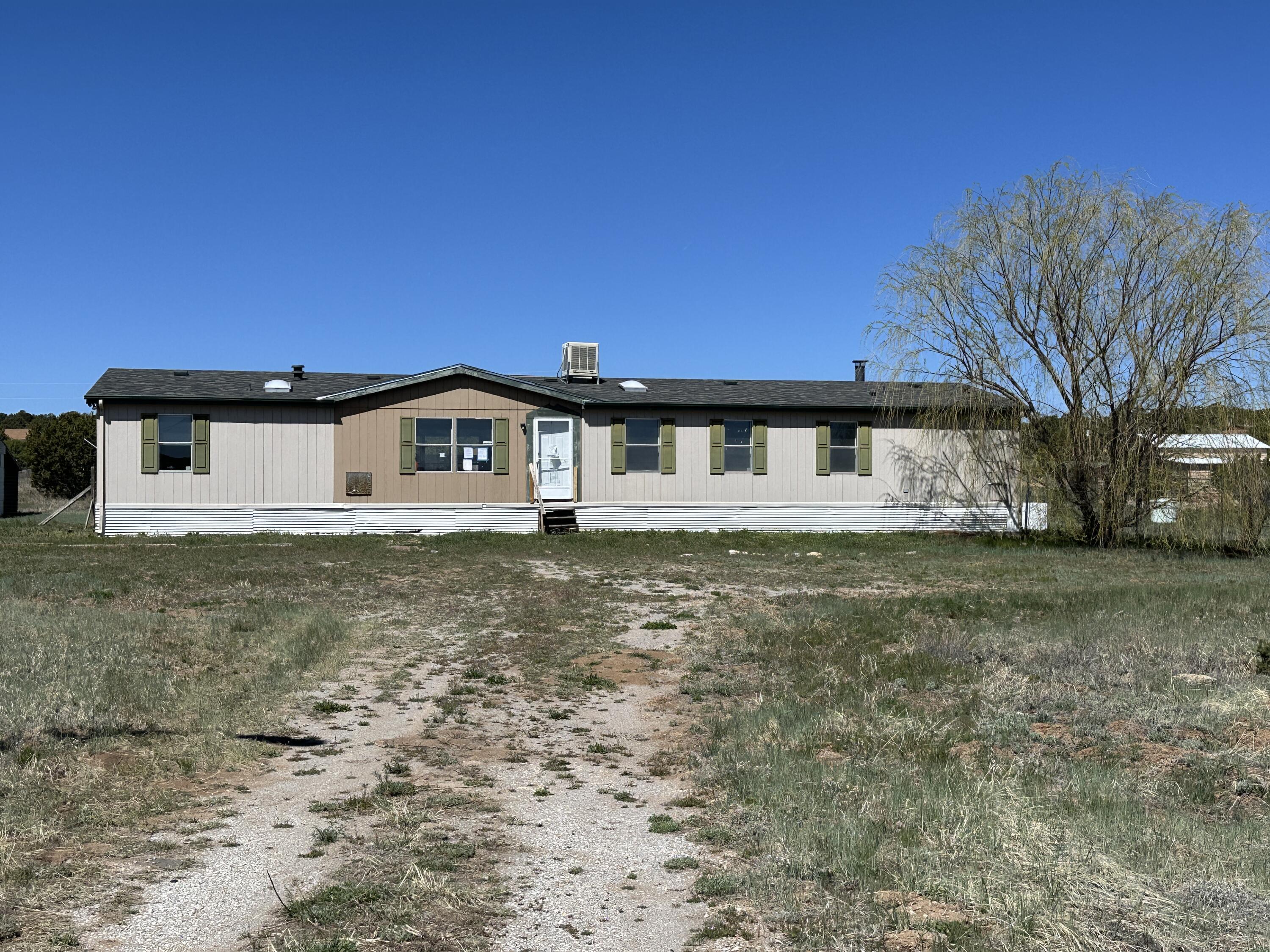 This double wide manufactured home has a large floorplan with 2 living areas, screened back porch, office off primary bedroom, several small barns for animals and sits on a large 2 acre lot. Home is eligible for $100 down payment program if using FHA 203 K Renovation financing.