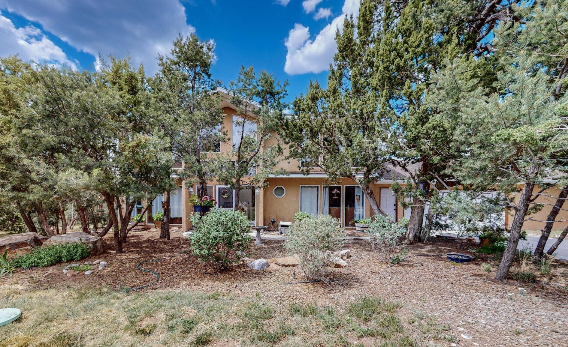 Owner says it's like living in a Treehouse in a Birder's Paradise.  This custom contemporary home is nested amongst the pines on a half-acre lot in Sierra Vista Estates which boasts an excellent community water system, a private park, and access to the Milne/Gutierrez Open Space for hiking and biking.  Established landscaping includes perennial gardens, a fenced grass back yard, RV storage, walking paths.  Ground level deck and 2 tree top decks for enjoying the views and privacy. Main living area on second floor has a flexible plan.  Custom hickory cabinetry and a large island in the kitchen with gas range, two large pantries and a planning desk.  Pellet stove heats the upstairs, mini splits in every room.  Main level has 2 large bedrooms, one in suite with bath.