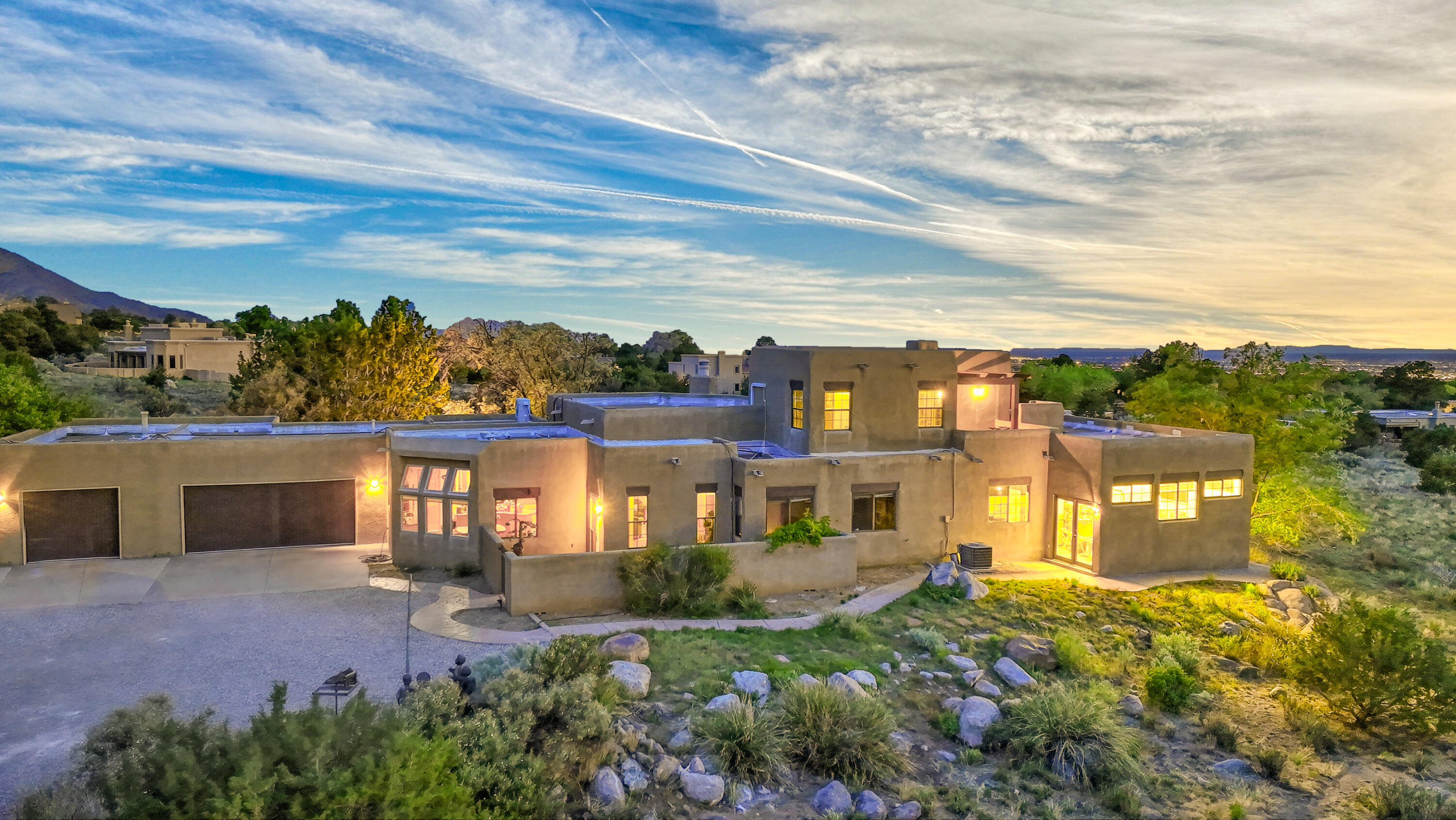 Nestled in the foothills, this house offers views of both the cityscape and the mountains. The clearstory windows, adorned w/ custom stained glass, fill the room w/ natural light. The kitchen is a chef's delight, boasting a pantry and an abundance of cabinets. Cooking is a breeze with the induction cooktop, which heats up quickly. The Viking outdoor BBQ is perfect for entertaining against the backdrop of panoramic views. Upstairs, the primary room offers views of both the city and Sandias. The versatile workshop area can be finished to create a second living space, providing endless possibilities. 3 bedrooms in the main house and casita accessible from the garage. The casita has a bedroom, living area, and 3/4 bath. Half of the third car bay was converted into storage.