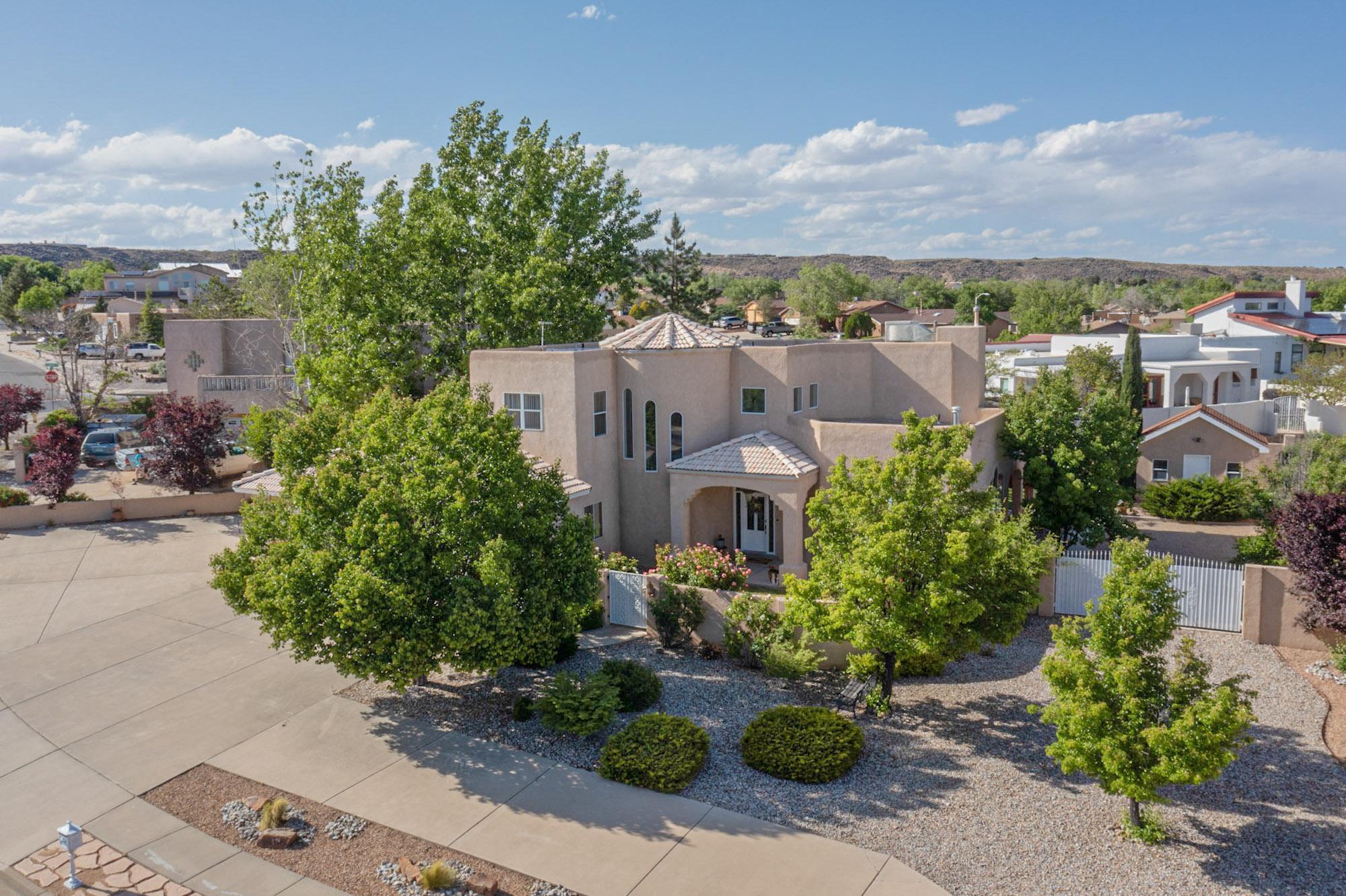 Gorgeous Custom Home nestled on a Huge Lot. This 2,953 square foot Home features 5 Bedrooms & 3 Full Baths with Granite Countertops. The Primary Suite includes a Deck with Impressive Sandia Mountain & City Views, an Ensuite with a Double Vanity, a Jetted Tub, and a Large Walk-in Closet. The Elegant Kitchen showcases Custom Cabinets, Granite Countertops, a Pantry, Stainless Steel Appliances & Double Ovens. Exceptional Features Throughout include Custom Curved Staircase, Medallion Ceilings, Wood Domed Vaulted Ceiling, Deep Nichos with Lighting, Beautiful Arches, Custom Tilework, an Abundance of Storage, Multiple Outdoor Living Areas, Off Street Parking for 12+ Vehicles & Backyard RV Access, and a Large Workshop or Potential Casita with Electricity. Close to scenic Petroglyph Hiking Trails.