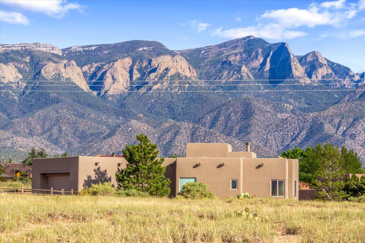 Enjoy panoramic views at this stunning home in Petroglyph Trails, Placitas. This fully furnished SW style home sits on 1.2 ac & would be perfect as a primary or second home. The kitchen & LR offer unobstructed views of the Sandia mtn providing a picturesque watermelon pink, while the office & spare bedroom face west with full Mesa views. The MB features south views of the beautiful evening city lights and the balloons over Balloon Fiesta Park. This home boasts a floor-to-ceiling slate tile fireplace in the living room, open floor plan & contemporary Southwestern style finishes, inc. stacked stone accents and vigas. It's equipped with matching SS Whirlpool appliances, including a gas cooktop, solid wood cabinetry & doors, skylights, lit nichos and a spacious 2.5 car garage. Selling as is.