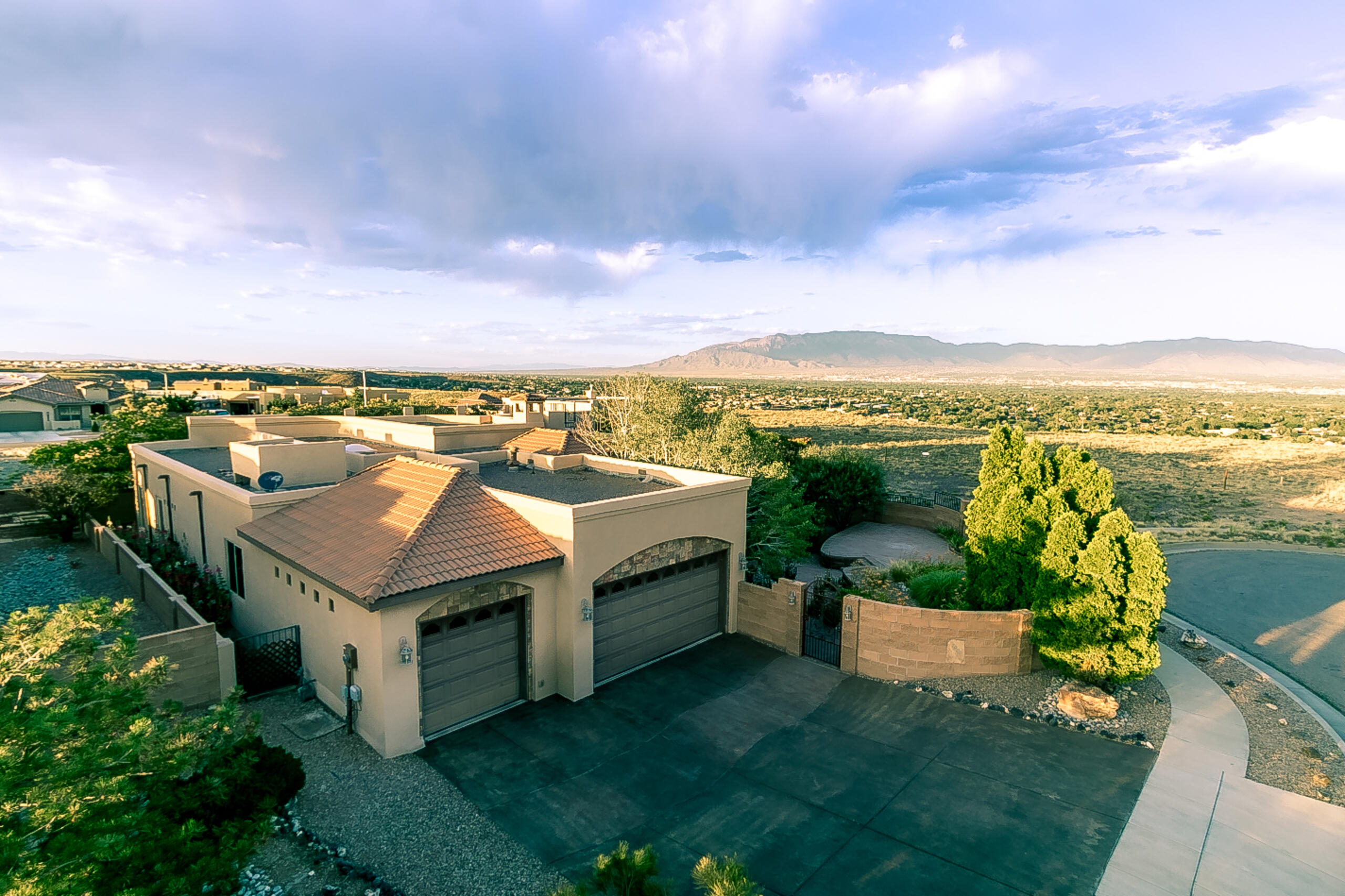 Views and a private garden oasis describe this custom home.  The home is in the much sought after Volcano Cliffs sub-division. All single level homes make up this beautiful community, with access to hundreds of acres of walking trails and open space. The Petroglyph monument is just blocks away for hiking and exploring.  The home has 4 bedrooms or 3 and an office, with 3 full baths 2 are Jack and Jill.  Home has views from inside and out including a view deck to capture the entire vista to the East ,North South and West.  Enjoy the private lush serenity of the gardens with water features and an outdoor fireplace.  Relax on the wrap around patio. Side bedrooms allows access to the outdoors where you can enjoy the views and add a hot tub, the hook up is already done. Come see it today.