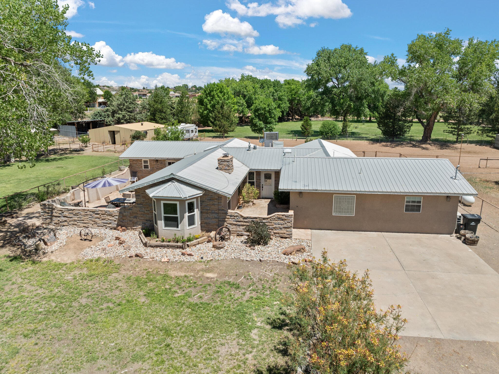 This exceptional property occupies 1.77 acres on Sichler Rd; one of the most sought-after locations in Los Lunas. Featuring approximately 2,838 sqft of living space, this home includes 5 bedrooms and 3 full baths. Updated features include a modern kitchen, dining and living room w/boasting vaulted ceilings! The second primary bedroom comes equipped with its own mini-split system, podium tub + walk-in shower. The property benefits from two wells, w/possible irrigation options and is fully secured with pipe fencing. Convenient side yard access leads back to equestrian amenities abound w/a barn featuring electricity, 4 stalls, a tack room, and well-lit arena. French doors open to a charming flagstone patio, featuring a built-in BBQ grill & fire pit, ideal for gatherings & outdoor enjoyment!