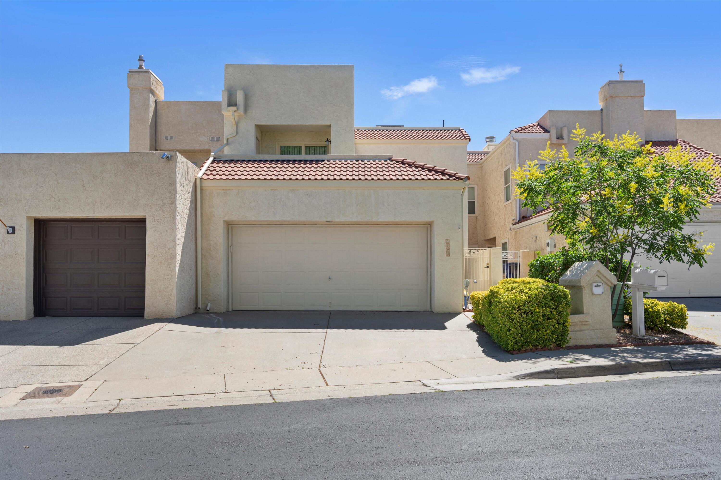 Beautifully kept townhome in Tanoan.  The property features a primary suite on the main level with a large bathroom and walk-in closet.  Upstairs bedroom has an adjacent bathroom, perfect for a 2nd primary suite.  Large loft space upstairs offers is a versatile space for your specific needs.  Nice size kitchen with an eat in area, formal dining room, and large living room with soaring ceilings.  Relax on your back patio with low maintenace artificial turf, and a lovely pond.  Updates in the last couple of years include a TPO roof, vinyl windows, and all new HVAC.  Come see this move in ready home today and make Tanoan your new home.