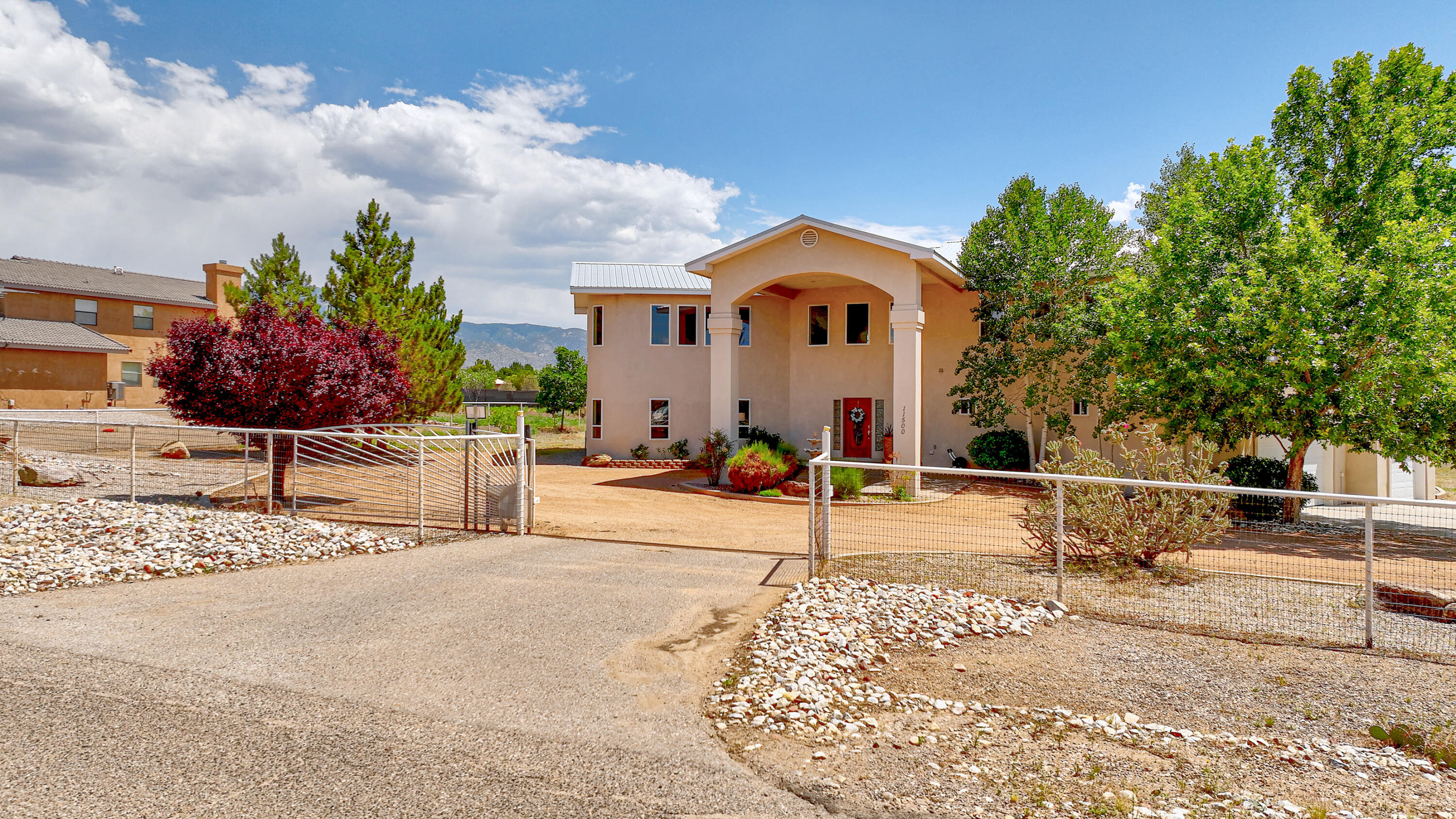 Beautiful custom home in desirable NAA. Gated entrance and circular drive lead you to a two story portico. The foyer with impressive staircase welcomes you. Main living area with its soaring 19 ft. ceilings, and multiple windows make it light and bright. Kitchen has  granite counters and SS appliances and is open to the living and dining room. Enjoy the game room with a wet bar. Polished concrete floors and radiant heat. Two generous bedrooms down with updated jack and Jill bath. Two primary bedrooms upstairs with their own bathrooms. Family room upstairs could be a playroom or gym. Large covered patio outside, blooming shade trees,& workshop/shed with electricity and cooling.  Plenty of space for a pool,horses, or RV parking. All of this plus gorgeous city and mountain views