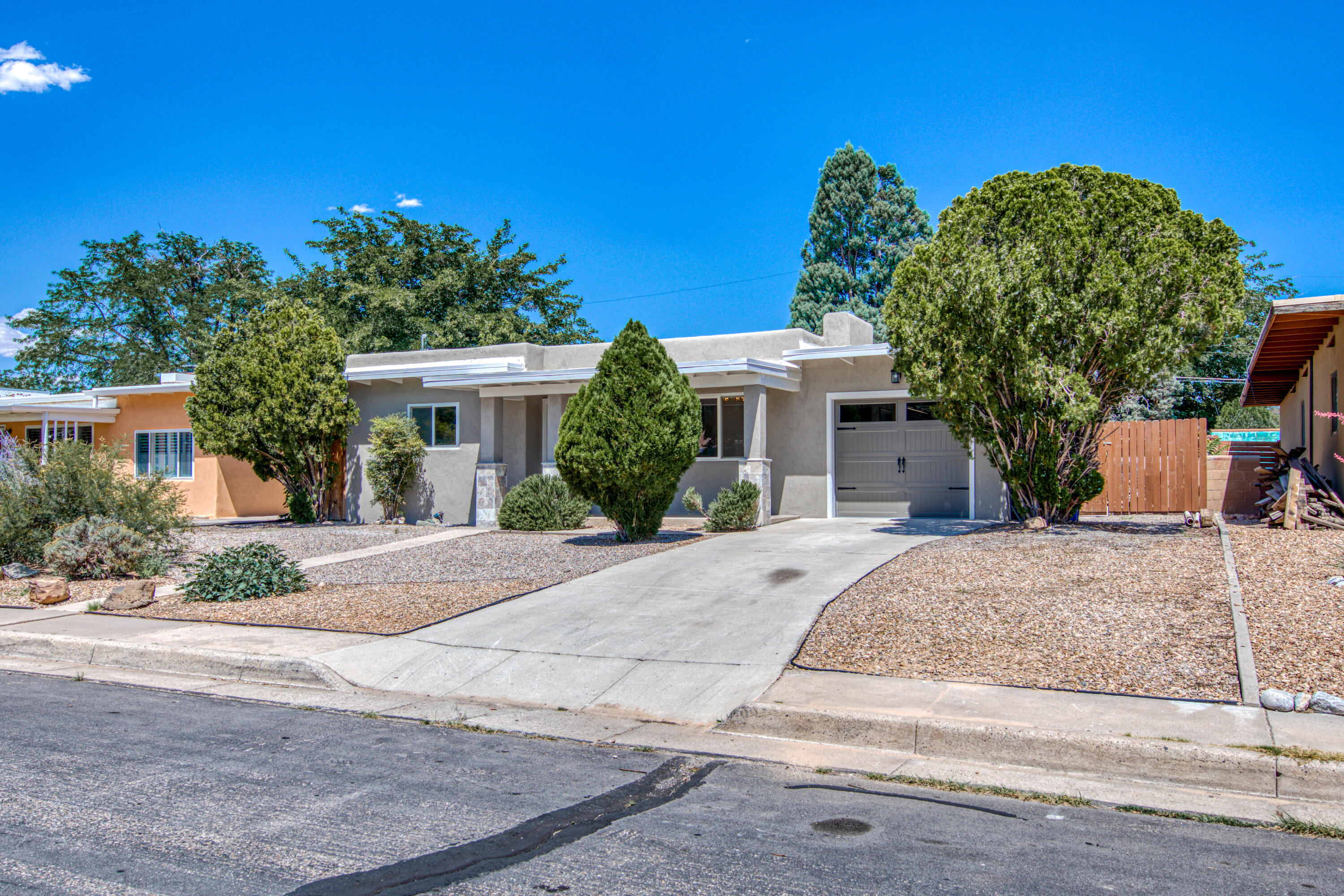 Nestled in a charming NE Heights neighborhood, this newly remodeled home is walking distance to Altura Park & quick access to I40 & I25. This home offers 2 living areas at opposite ends.The first area has an electric fireplace to enjoy & relax, the other area has an EPA rated wood burning stove to enjoy during the chilly winter months. The kitchen has custom cabinets, porcelain countertops & new LG appliances. The owners suite is separated from the other 2 bedrooms with an ensuite bathroom; walk in shower, 2 vanities,freestanding tub & walk in closet. The attached 2 car tandum garage is wired for electric car charging & contains 2 garage doors with full drive thru access to the backyard. Additional upgrades include flooring, central heating with refrigerated air, new plumbing & electrical