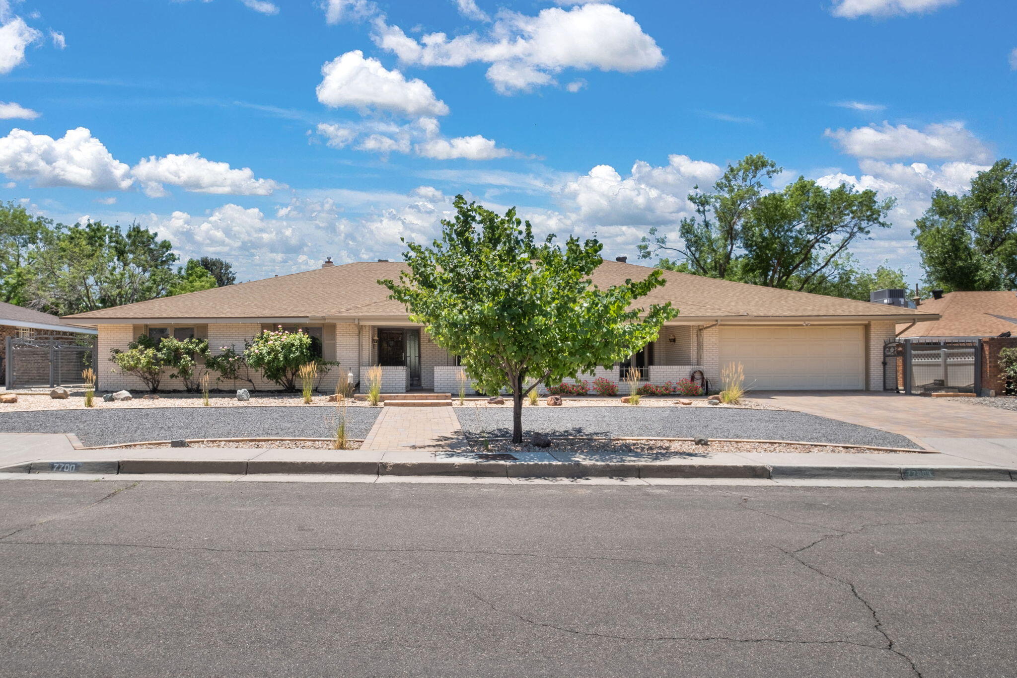 This exquisite single-story brick home backs onto the Arroyo del Oso Golf Course, and boasts breathtaking course and mountain views! No HOA fees! Enjoy open concept ambiance with expansive and bow Pella windows, laminate flooring, cathedral ceiling, a stone fireplace and wet bar. Formal dining room. Your home features two spaciousprimary bedrooms on opposite ends, 2 HVAC units, 2 water heaters, updated bathrooms, a huge laundry/mudroom. Abundant storage.Walk-in pantry. A beautiful fully fenced landscaped backyard with fruit trees features a heated/cooled room for a gym/studio/office with views! And a dual loft shed with power. Direct gate access to the golf course! Conveniently close to supermarkets, schools, and recreation. Envision a lifestyle - of elegance and convenience and ease!