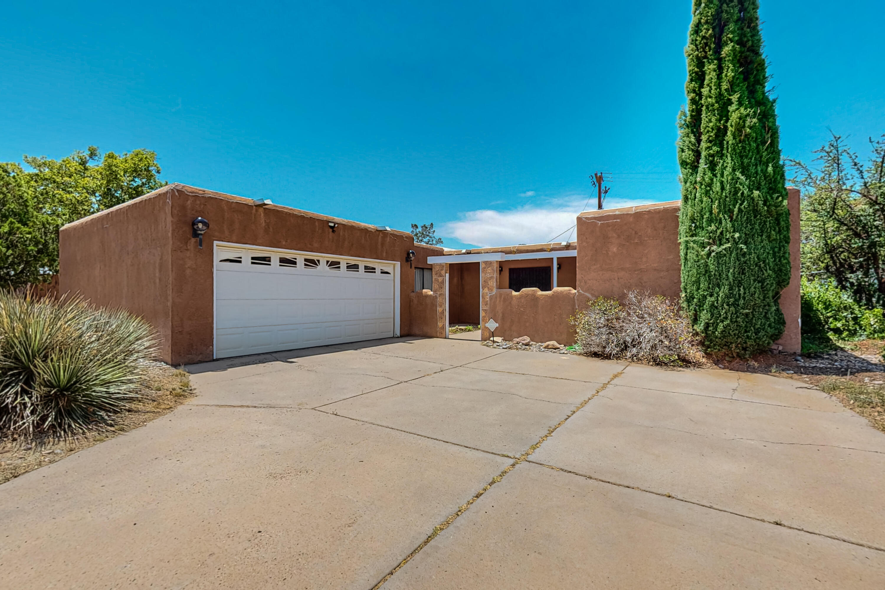 READY FOR AN OFFER! Fantastic NE Heights location! Close to everything: shopping, restaurants, schools, parks, I-40 & I-25. This lovely 3 bed, 2 bath home has new TPO roof that was installed in June 2024 w/transferable warranty, fresh paint throughout & updated laminate flooring in some rooms. Nice sized living room w/wood burning fireplace & natural rock suround. Kitchen has woodlike accents & dining area, along with newer appliances that stay, a pantry & open shelving. Primary bedroom has newer walk in shower & is separate from the other bedrooms. Laminate & tile only-no carpet. Front courtyard has room for patio set & plants & flowers. The private backyard has a covered patio that is perfect for BBQ's, pets, & fun times. Large driveway has room to park extra vehicles, boats, or RV's.