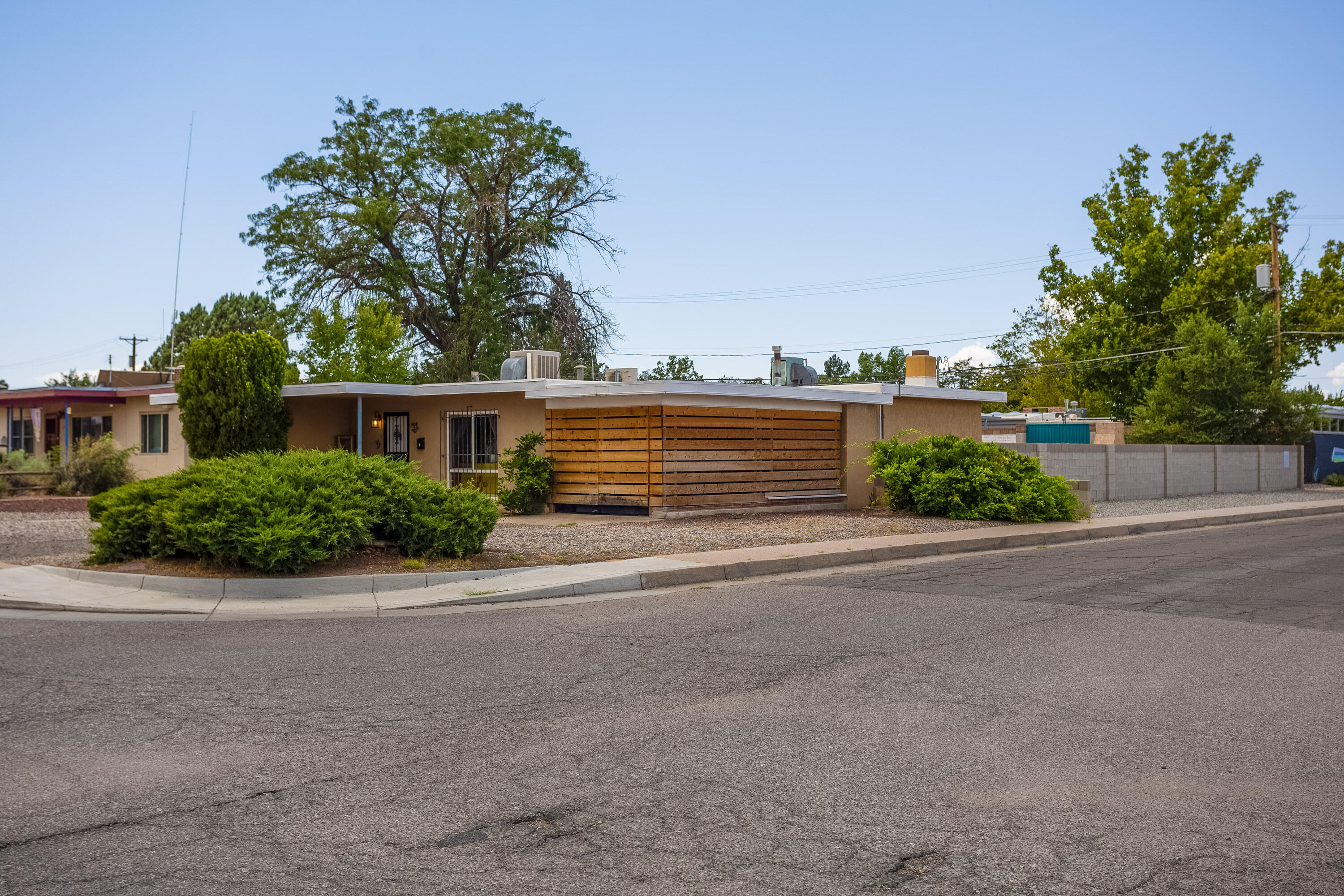 Amazingly convenient location close to UNM, Uptown, Whole Foods, Nob Hill & more. The house offers great versatility with a huge living room that opens to the even more spacious backyard. Off the alley is a driveway so you can access the large shed which is big enough to be a bike or motorcycle garage. An open patio area and tons of space give you plenty of room to make it your own. Add a garden, dog run or whatever your heart desires. Inside you'll find lovely light, a large laundry room with extra storage, a walk in closet & seating area in the oversized primary bedroom, & two nice-sized secondary bedrooms. The front room - currently used as a dining room - could easily be a second living area. A secure closed in carport on the front of the house can be used for parking or so much more.