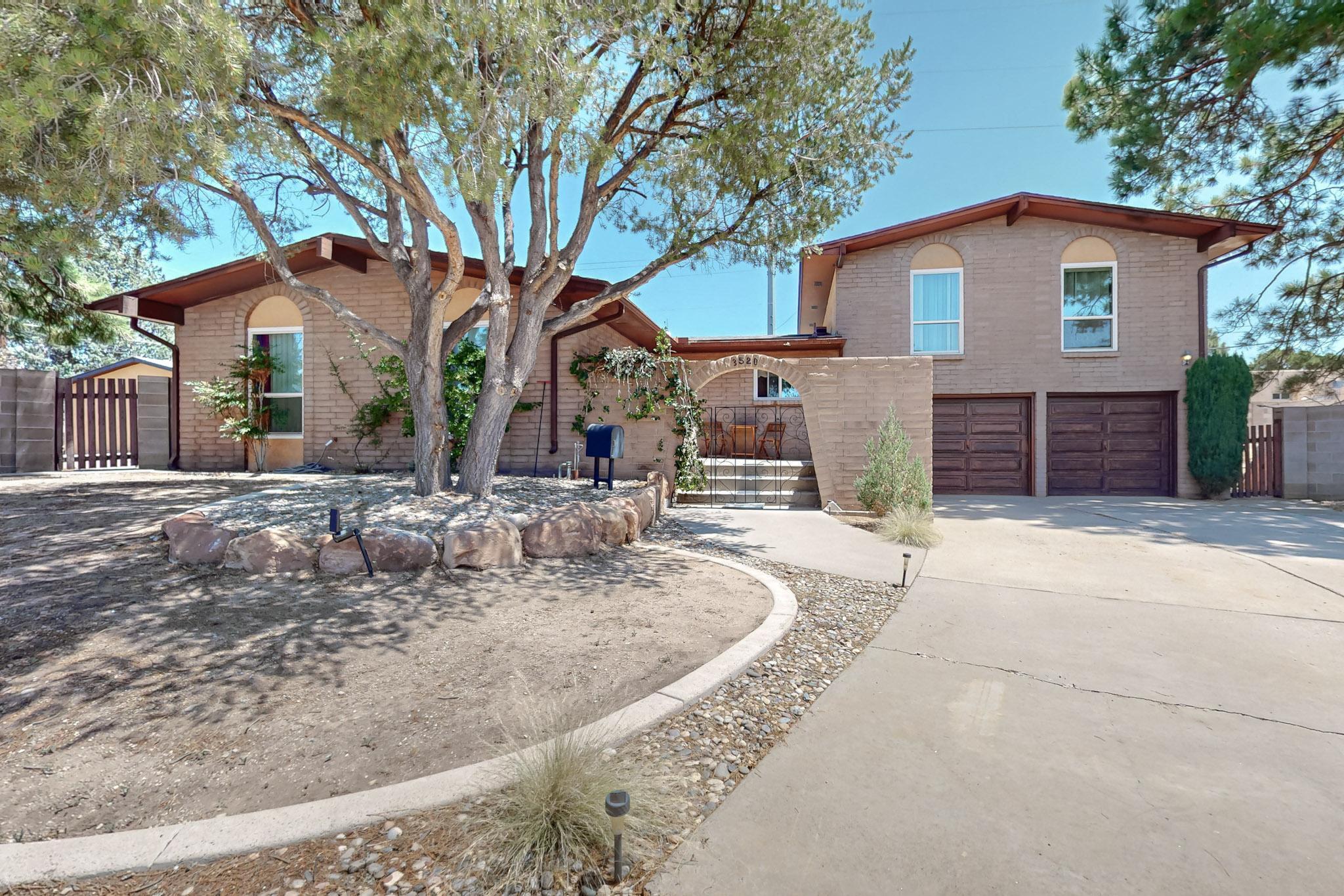 Wow!  The 1960's never looked so cool!  This incredible custom split level brick house is the perfect vintage home in UNM North campus.  HUGE .35 acre lot with a large detached 2 car garage/workshop & an attached oversized 2 car garage.The main floor has 3 bedrooms, 1 with an ensuite, an eat-in kitchen, a formal living room & designated dinning space. Upstairs boosts another ensuite w a balcony and a  great room with built in wet bar & a groovy 2 burner cook top, mini fridge & a stone fireplace with custom book shelves flanking either side.  There is even a custom cork wall!  So many original features that must be seen!  This is a one of a kind opportunity for any Buyer that requires plenty of garages & the possibilities are endless with this massive lot size in the UNM area!