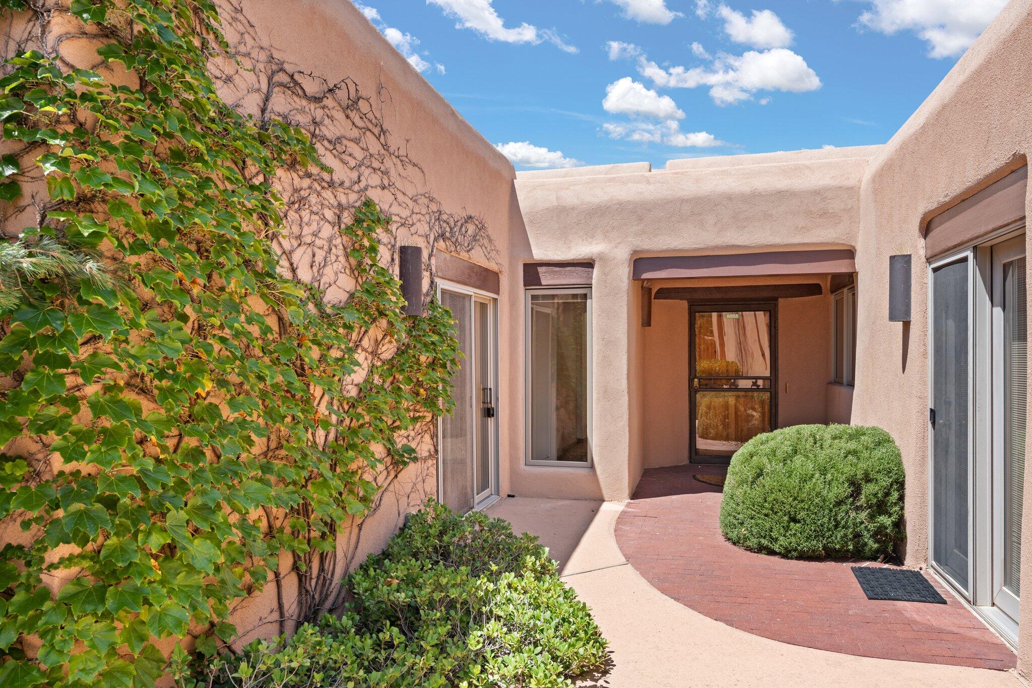 This custom estate embodies the essence of Southwest charm with its striking beam ceilings, Saltillo tile flooring & a standout feature - IN-LAW SUITE with its own living area and direct access to court yard. The floor plan of the house is thoughtfully designed for effortless living and entertaining. The living room, reminiscent of a mini concert hall, bathes in natural light, offering the perfect ambiance for gatherings. The grand primary suite is a true retreat, featuring a cozy sitting area, a warm fireplace, & a massive walk-in closet. The majestic panorama of the Sandias accompanies you as you enjoy the sunsets & sunrises. This exceptional property, a rare gem in the sought-after North ABQ Acres, is a unique opportunity to own a piece of authentic New Mexican architecture