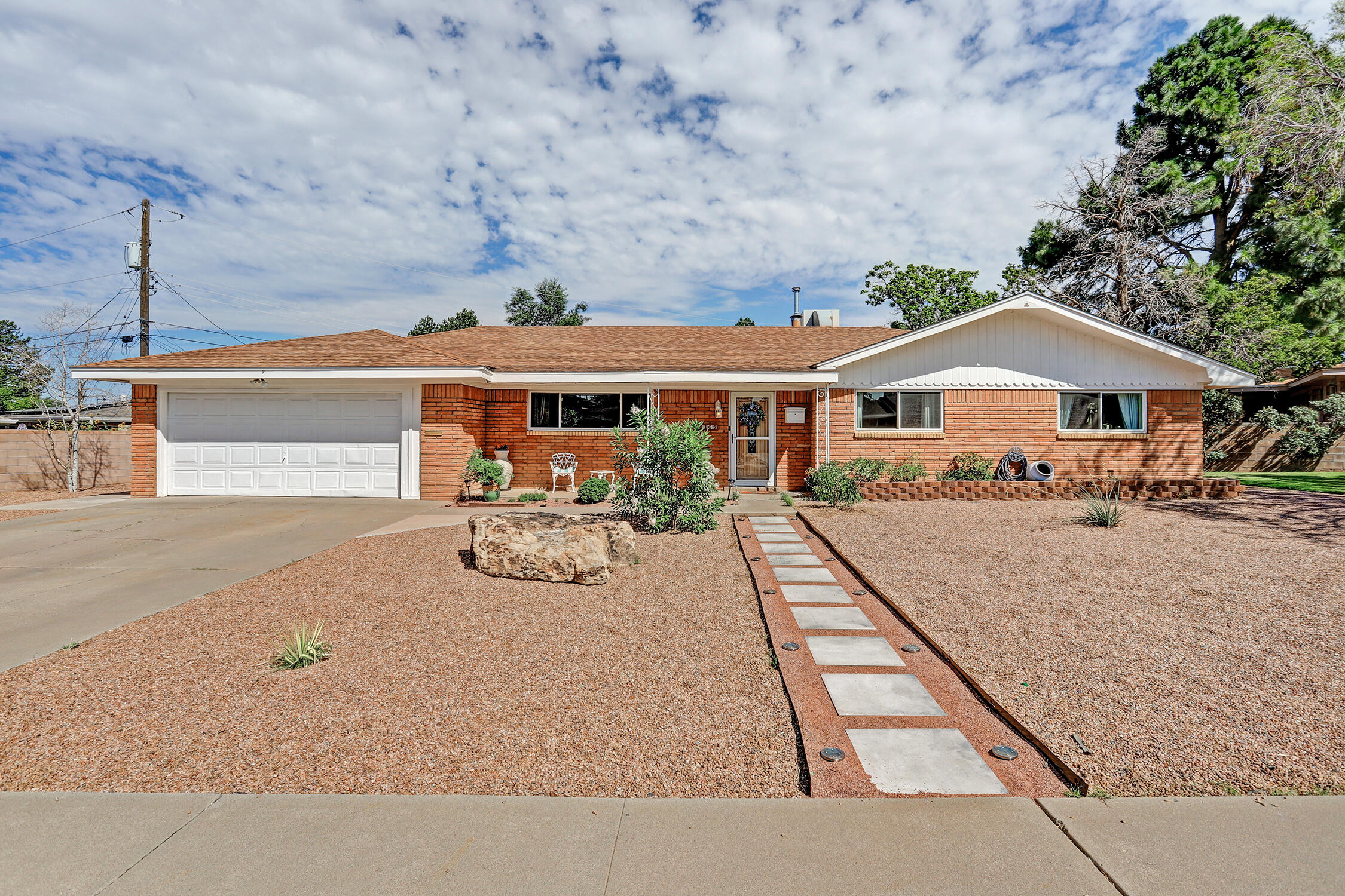 Wonderful single level brick home in Dellwood subdivision in Uptown.  Light and Bright with tile flooring in main living areas. Flexible floorplan offers 3 beds and 2 baths with 2 living areas and lots of storage! Kitchen has excellent cabinet space and a large walk-in pantry. Living area features a custom fireplace, Patio doors open to the sweet backyard with a large covered patio. Excellent location waking distance to Sandia HS, and minutes from shopping and dining at ever evolving uptown.