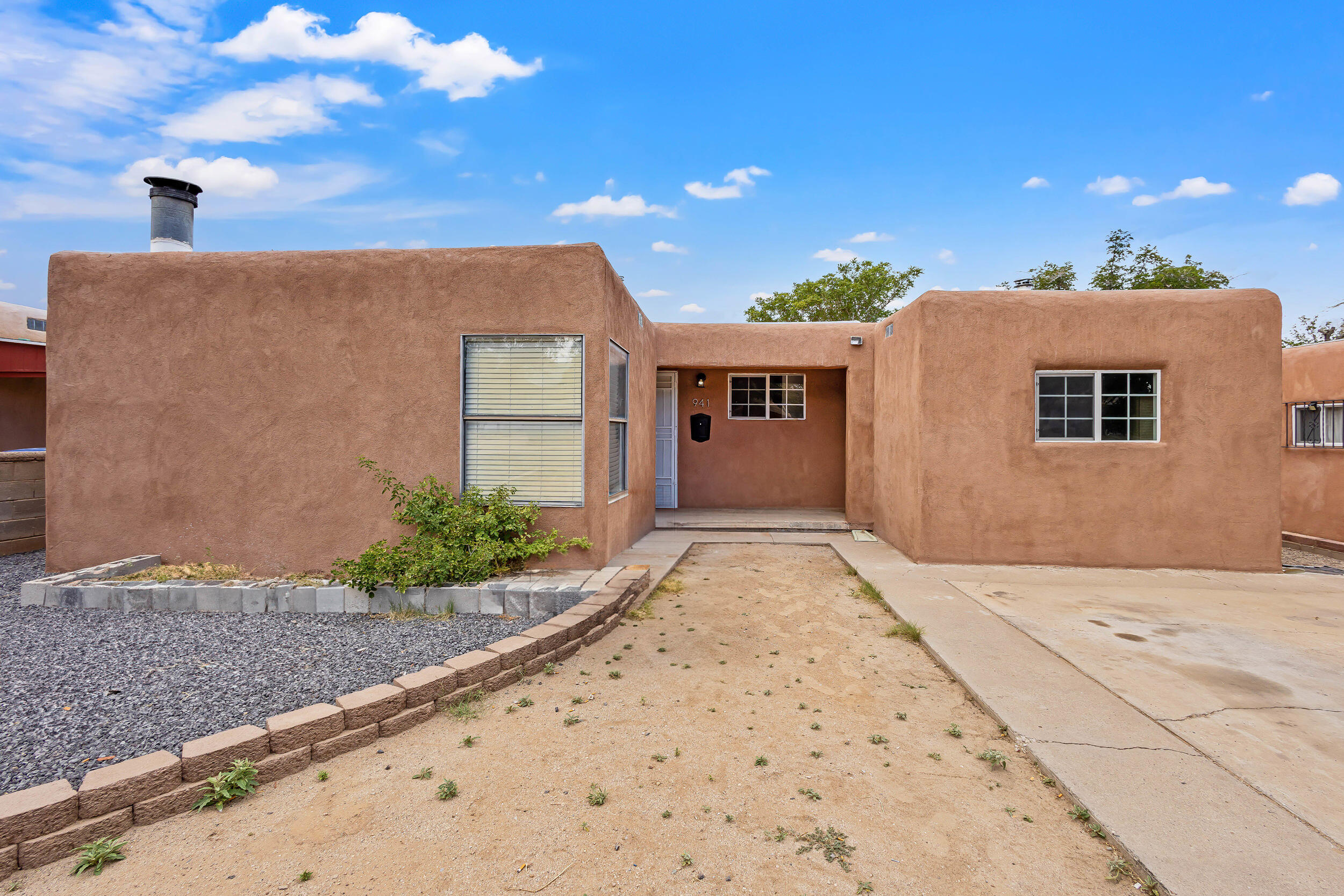 Welcome to this Pueblo-style home in Albuquerque! featuring 1,556 sq ft of living space with 3 bedrooms and 2 baths. This lovely home boasts a brand new TPO roof, new interior doors, and updated plumbing throughout. The kitchen has been thoughtfully redesigned with new cabinets and stylish tile countertops! Situated on a large lot with backyard access, perfect for parking your toys, and includes a one-car detached garage.