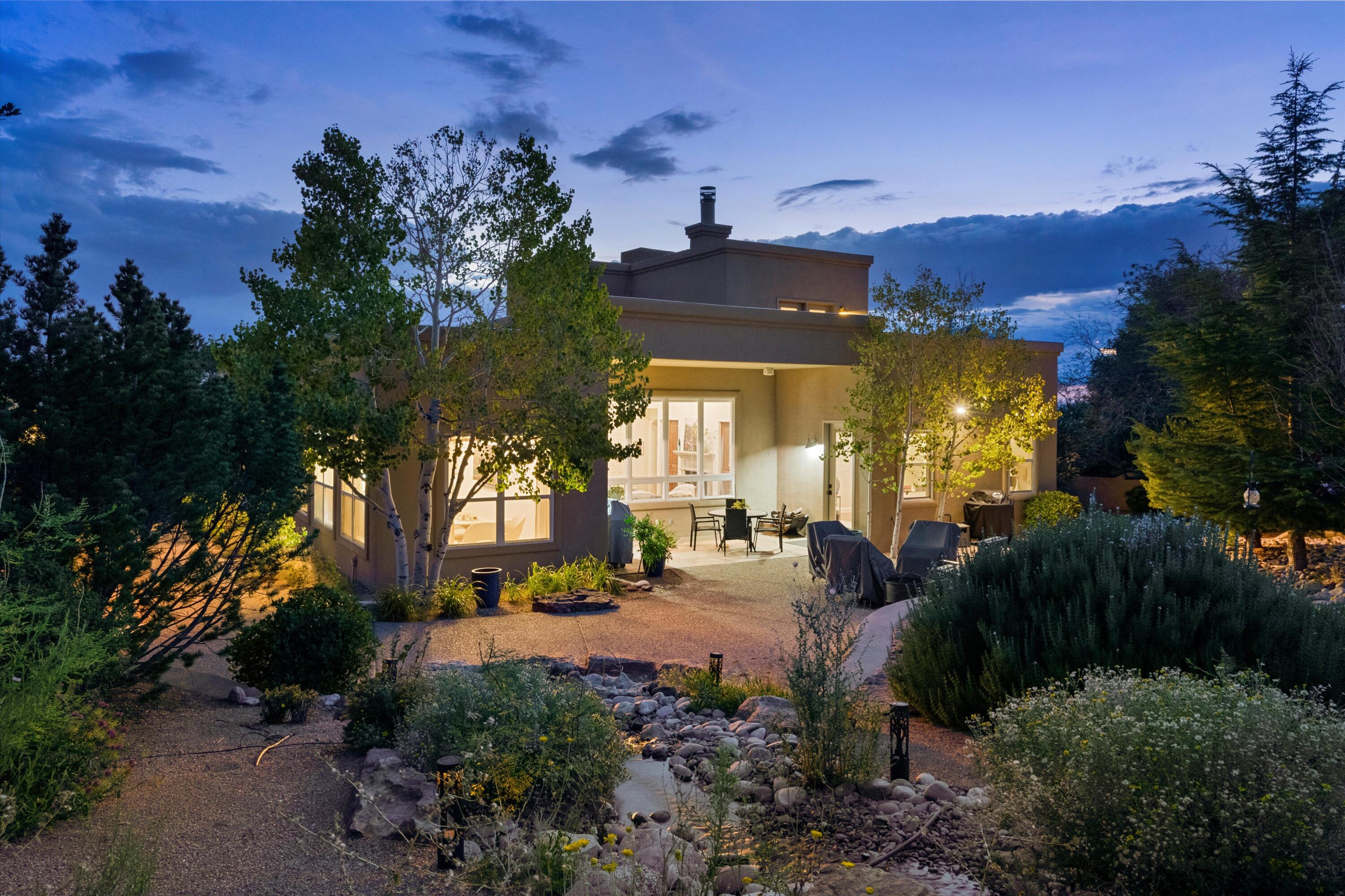 Welcome to this beautiful home in the highly sought-after High Desert neighborhood. Offering stunning views and a great floor plan that seamlessly blends indoor and outdoor living spaces.  The first floor boasts a magnificent living room with a beamed ceiling, luxurious radiant-heated flagstone floors,  a gas fireplace, and great views of the Sandias. The custom kitchen features sandstone countertops and top-of-the-line appliances, including a sub-zero fridge. The family room provides plenty of space for relaxation and/or a workspace. The main floor Primary suite serves as a tranquil retreat. Upstairs, you'll find 2 spacious bedrooms and a deck offering spectacular views of the mountain range. Outside, relax in the backyard oasis with a soothing waterfall, covered patio.