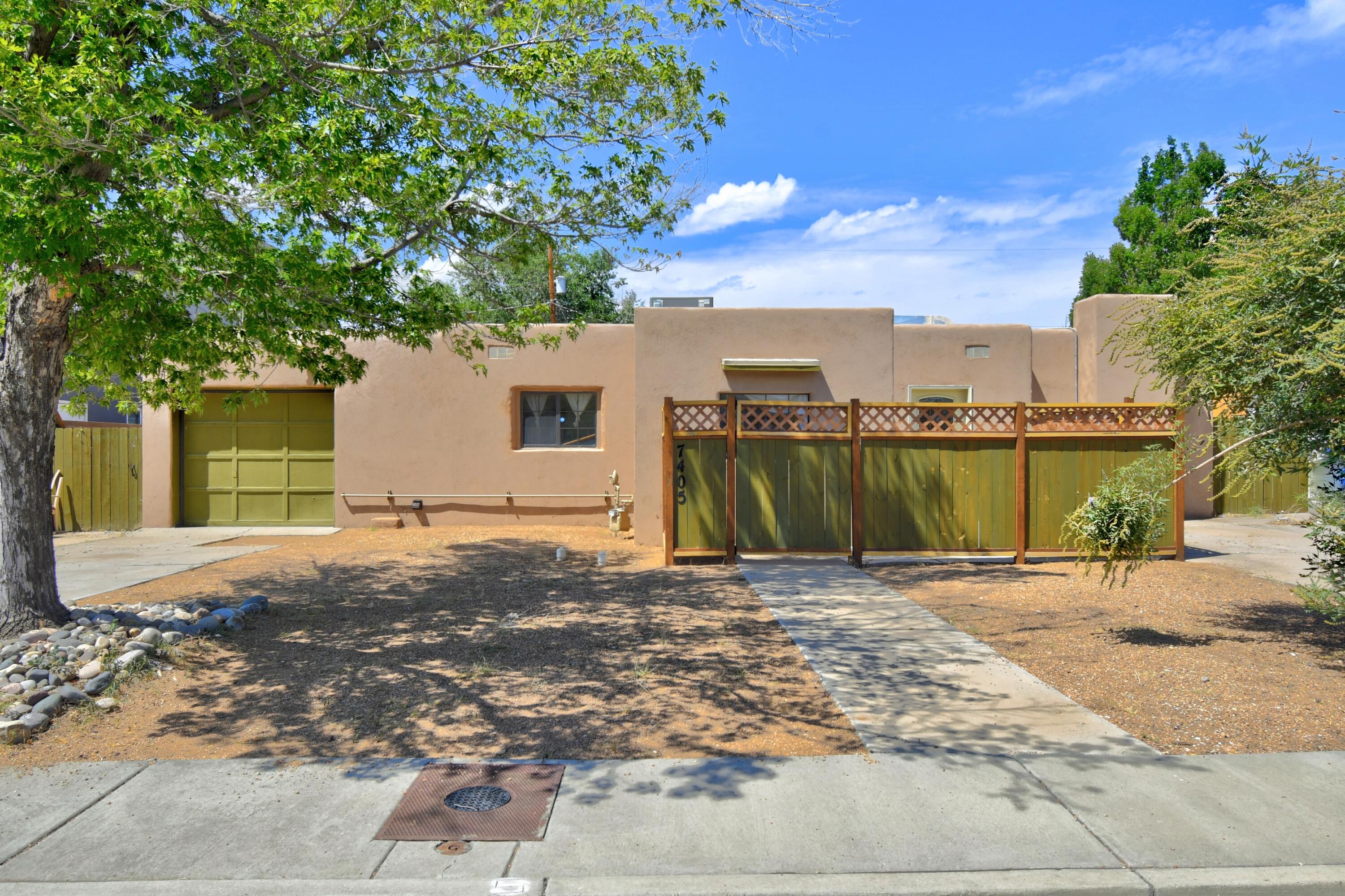 Welcome to this charming 4-bedroom, 2-bathroom home, offering 1,961 sq ft of comfortable living. Enjoy a spacious living room and separate den with a cozy 9,000 BTU fireplace, plus a formal dining room off the modern kitchen. The home features a stylish courtyard entry, tile and laminate flooring, and carpeted bedrooms. Modern upgrades include HVAC system and electrical panel. Relax in the large yard with a covered patio. Enjoy fresh pears and pomegranates from your own backyard. Conveniently located near ABQ Uptown, Trader Joe's, and I-40. Plenty of parking with two driveways. Your perfect blend of comfort and convenience awaits!