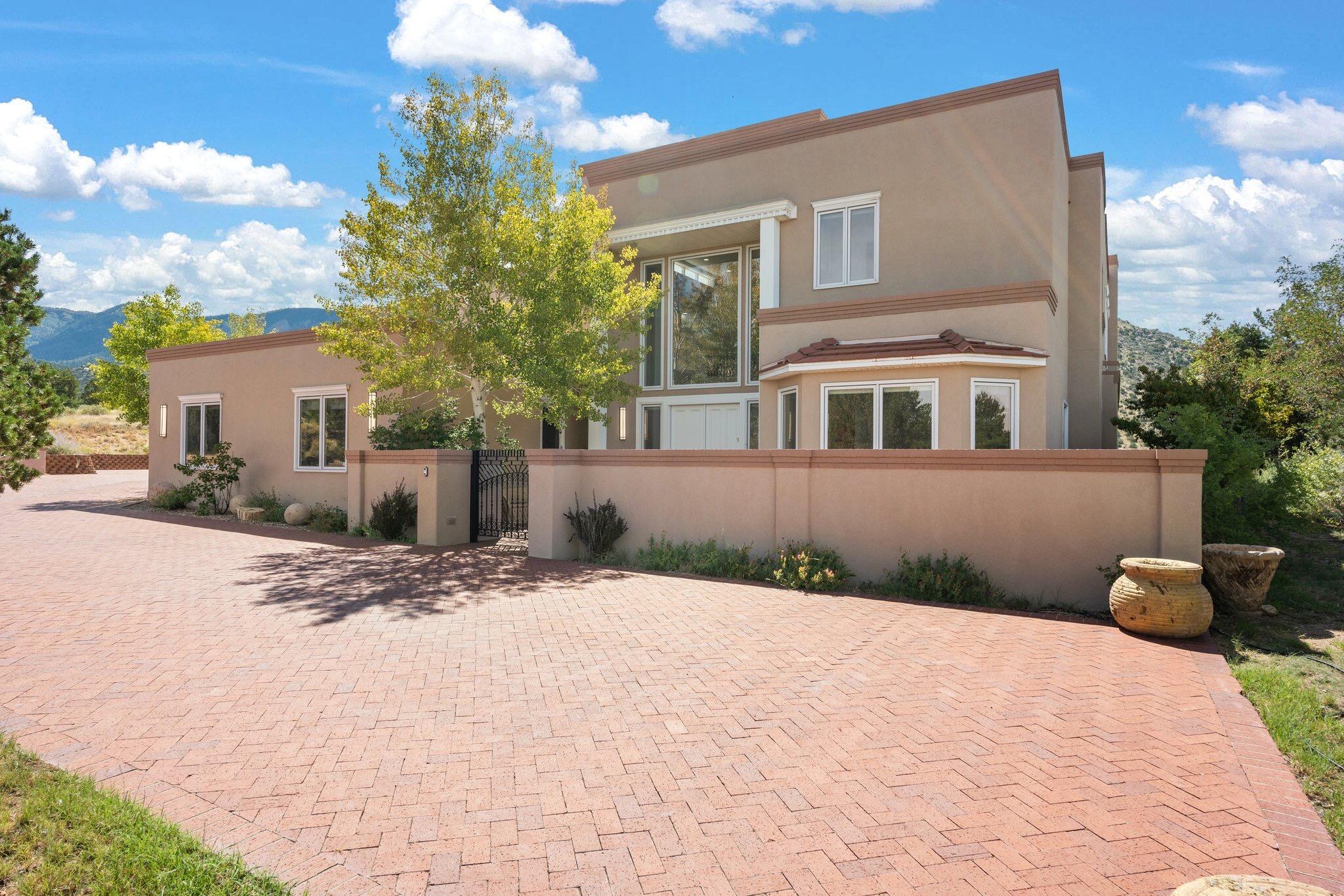 High Desert Beauty! Enter through the grand 10 ft double doors and be greeted by a dramatic foyer with a sweeping staircase and exquisite chandelier. This timeless home features elegant plaster walls and rich wood floors throughout. The magnificent formal dining room opens to a resort-like great room with a cozy fireplace and multiple sets of French doors leading to a patio with stunning mountain and city light views. Situated on a private 1.52-acre parcel backing to Open Space, this home offers ultimate privacy.The chef's dream kitchen is outfitted with top-of-the-line commercial appliances, including a 10-burner Viking stove, double wall ovens, Sub-Zero refrigerators, and a built-in freezer. Dual dishwashers and an ice maker add to the convenience,