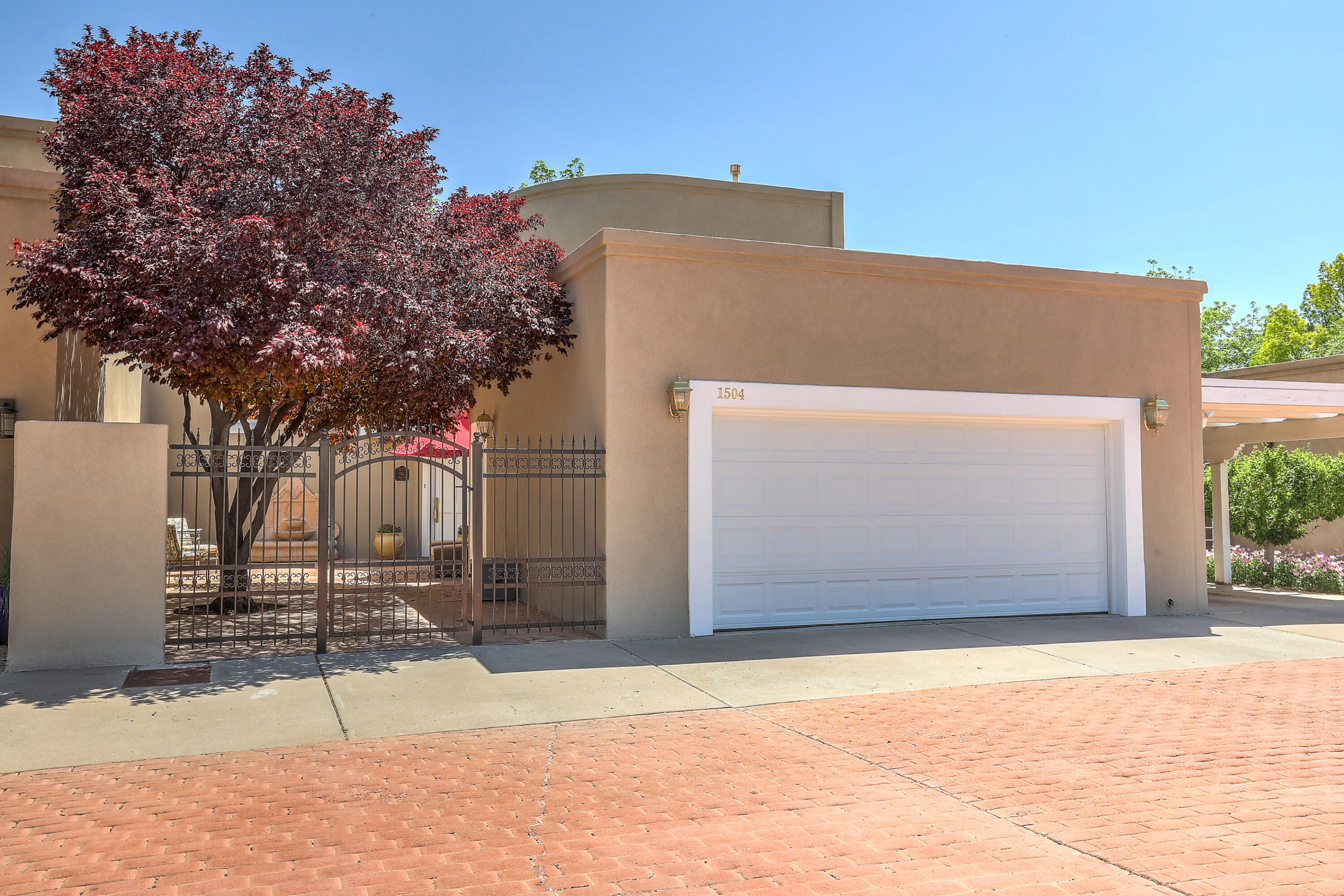 Stunning, gorgeous townhome in fabulous gated North Valley location within a private, gated community, offering easy access to miles of trails, open space, a park & the Rio Grande bosque. Recent updates to this move-in ready home include new luxury vinyl flooring that looks just like real hardwood (without the maintenance), tpo roof, updated lighting, stucco, and freshly painted cabinetry.  The house features soaring ceilings, light & bright rooms, custom doors, crown molding & built-in cabinetry. The kitchen is designed for a gourmet cook with a lovely breakfast nook looking onto the private flagstone courtyard. Savor the primary downstairs suite with its' light-filled bathroom, spacious shower & large walk-in closet. Enjoy easy maintenance living in this lovely home. It's a 10!