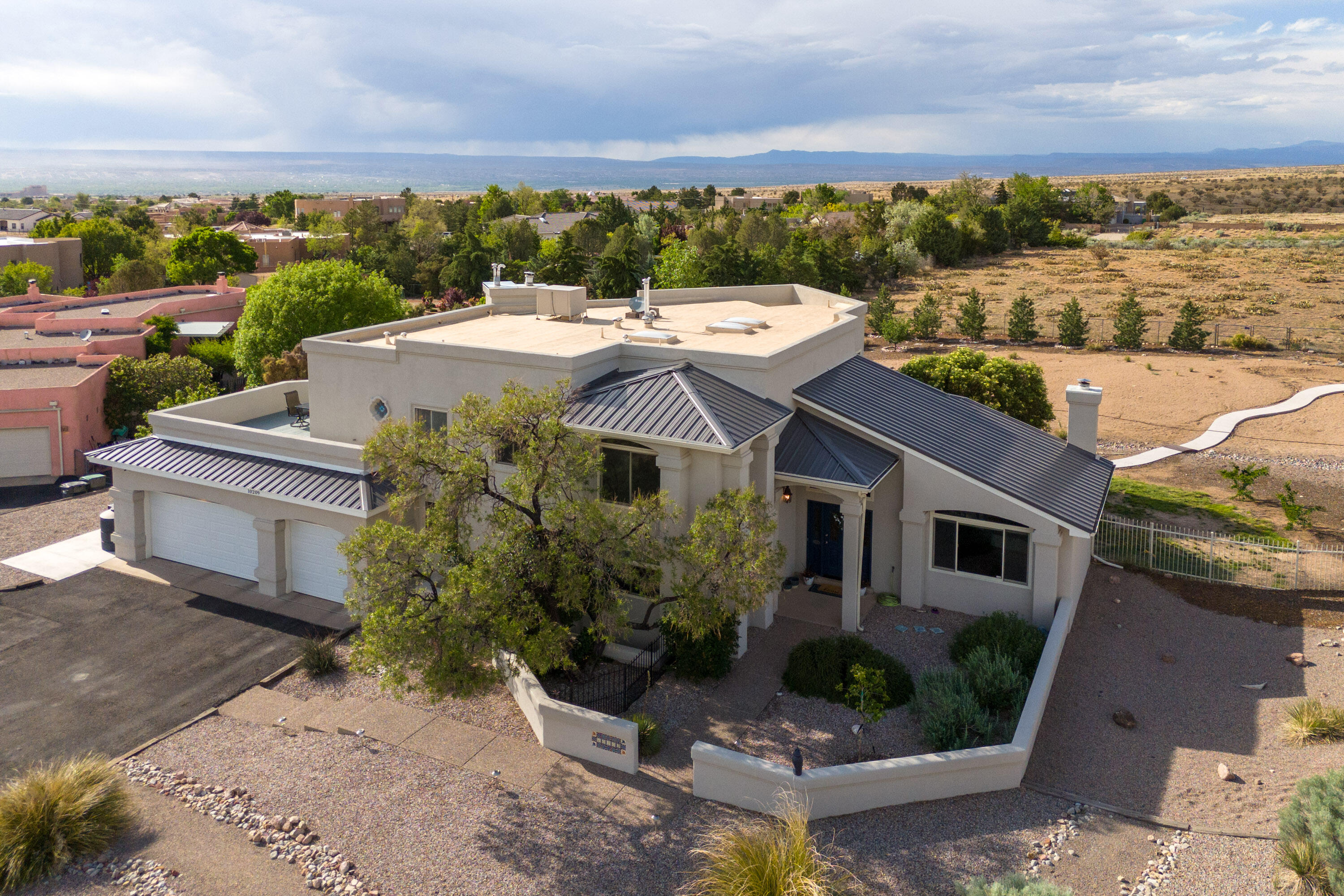 RE-LIST:  This absolutely stunning North Albuquerque Acres property sits on a .89 acre lot with gorgeous views of the Sandia Mountains above and the Western Valley below.  Saltillo tile welcomes you as you enter this spacious and meticulously cared for home.  The primary suite is located on the first floor with en suite bathroom, soaking tub, and walk-in closet. The kitchen, a food-lover's dream, comes fully equipped with a 60'' Wolf stainless steal 6-burner gas range.  Additional bedrooms and office space located upstairs with two full baths and large deck to watch the setting sun.  Mature trees and southwestern landscaping complete the front and backyards.  Newly built shed/greenhouse combo is nestled in the backyard for a green-thumb's paradise.  Schedule a showing today!