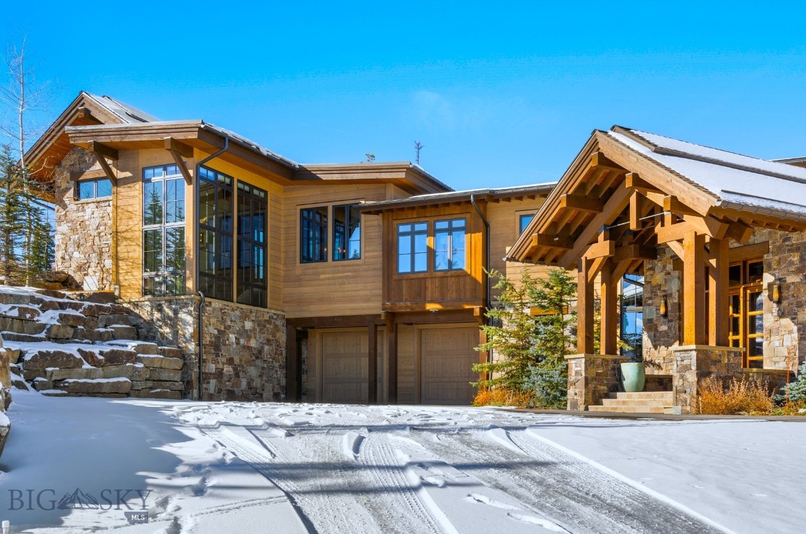 This majestic Moonlight Basin residence in the coveted High Camp neighborhood, checks all the boxes, with elegant finishes, stunning panoramic views, thoughtful entertaining and sleeping spaces, unbeatable ski access, all in an unparalleled location in Montana’s most desirable ski area.  Offering 6 bedrooms and 8 bathrooms, this oasis sleeps 20 comfortably on three levels, luxuriously accommodating large groups or intimate gatherings. The stone entry boasts the first glimpses of the formidable stone accents featured throughout the home, with the grand hall revealing a vast timber-framed ceiling with forged iron accents and a floor-to-ceiling fireplace with a 3,500-pound hearthstone. The commanding views from much of the residence are truly magnificent; wide open Spanish Peaks and Lone Mountain views are everywhere. Giant sliding doors off the dining area access the adjacent covered porch, with motorized screens, comfortable seating and more stellar views.  The kitchen has custom cabinetry and lighting, walk-in pantry, an inviting breakfast nook and an ample bar. The ascending and descending stairwells from the grand hall are set against a wall of windows that provide profuse natural lighting, reaching from the heart of the home to the lower level.  Walnut wrapped stair treads feature inlaid travertine and custom iron railings fortify the stairs with hand hammered artistry. The main level primary suite feels a world away from the hub of the home, with its cathedral ceiling, fireplace, sitting area, bath and walk-in closet. A wall of custom steel artistry is the signature item of the lower level, depicting Lone Mountain at night, which impressively divides the lower-level hallway from the media room; wooden barn doors on a 36-foot track slide together to offer privacy. The media room and all 3 guest suites have access to the exterior stone patio, yet more views, and glimpses of the abundant resident wildlife. On the main level, ascend the floating stairs and traverse to the home’s guest quarters and ski lounge, with direct access to the groomed Natawista and Cinnabar ski runs. The guest area also has a private entrance, kitchen, living area, fireplace, wall bed and full bath. The lounge has plenty of lockers and cubbies just inside the ski-in entrance, complete with boot and glove dryers and ski racks. Call to arrange a private showing of this spectacular, one-of-a-kind, slope side offering in one of the most desirable natural environments in the West!