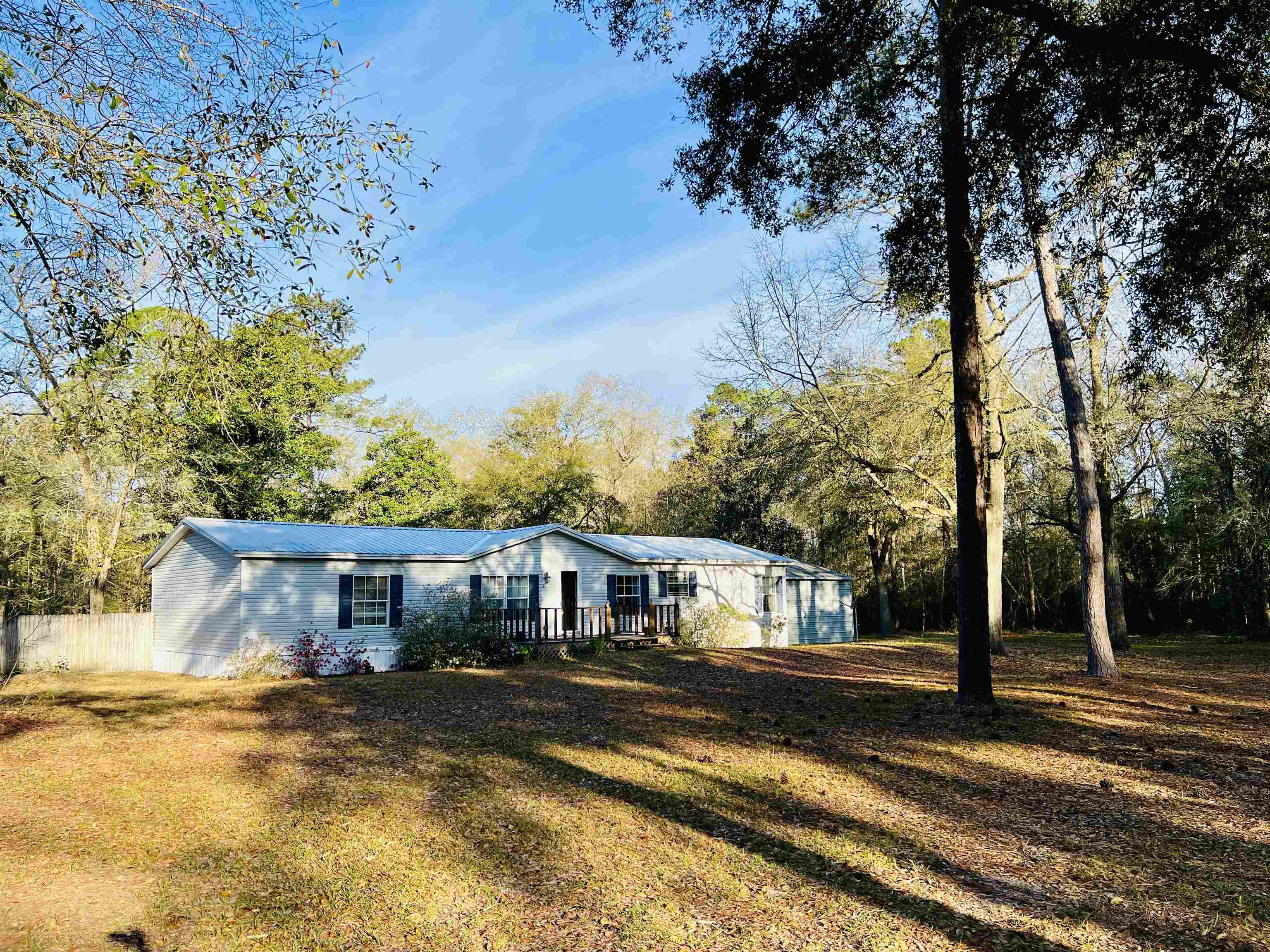 Very quiet private gated community located on beautiful Lake Talquin. This home is  3 bedroom 2 bath  with a  screened  covered porch overlooking a  fenced backyard. There are two living areas with an open concept and a split bedroom plan. There is a 12x24 storage building on site that could be converted for workshop or a hobby room. Big yard perfect for boat storage or enjoyment. This home is not on the water but has access to a community dock for fishing and a small boat launching ramp with a nice picnic area. Nature at its very best with fishing, kayaking and hunting within minutes of this location.